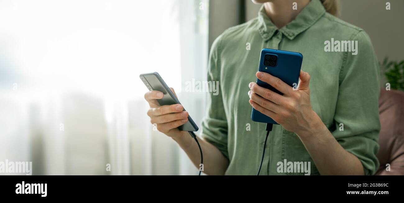 Datensicherung - Übertragung von Informationen vom alten auf ein neues Telefon mit Kabelverbindung. Platz kopieren Stockfoto