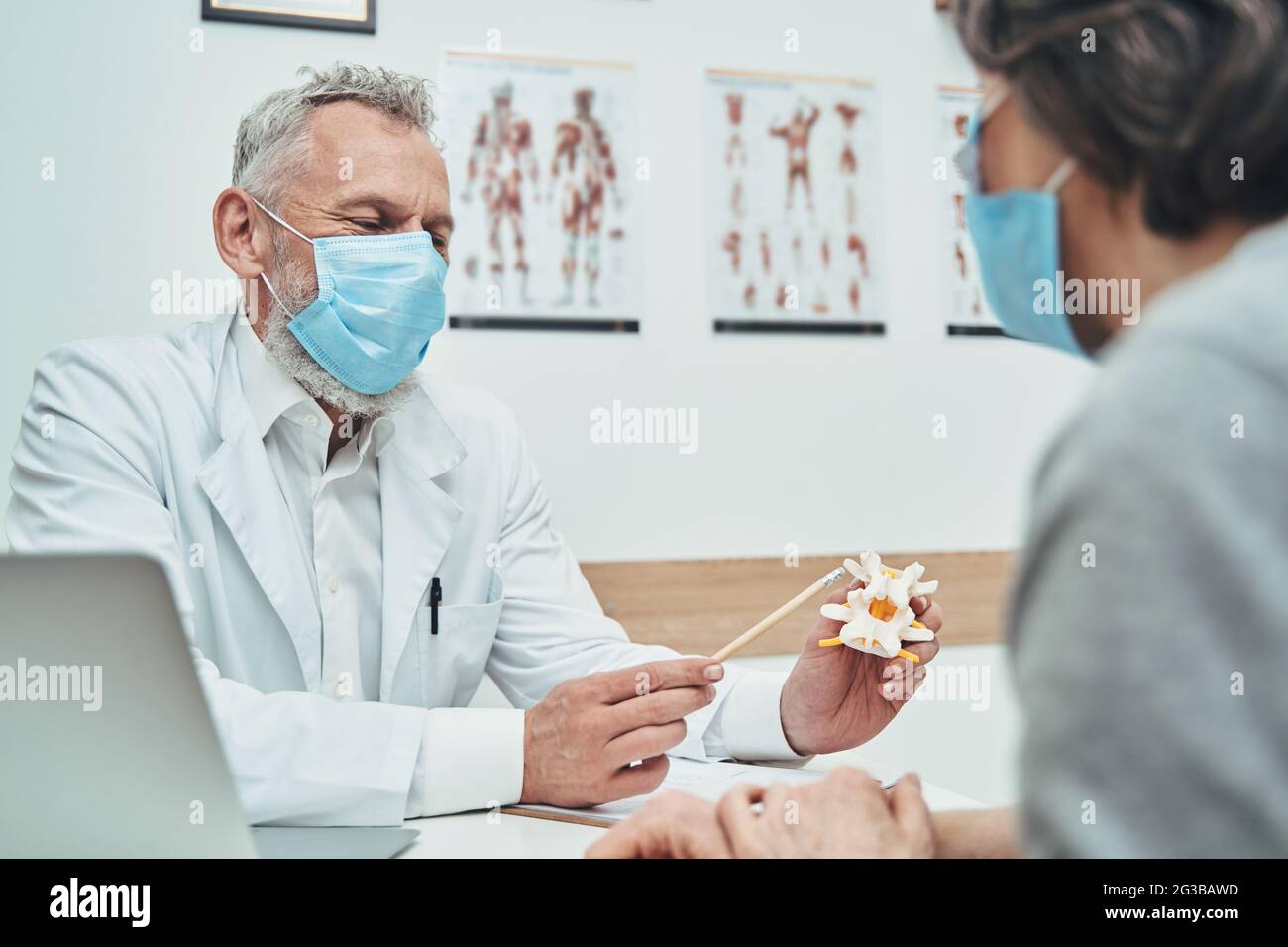 Der Arzt erklärt die Grundlagen der Wirbelsäulenanatomie während der Patientenkonsultation Stockfoto