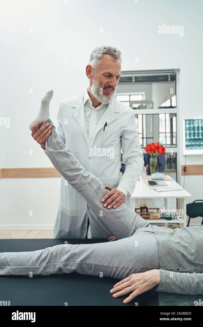 Vertebrologe führt einen Test zum Anheben des geraden Beins durch Stockfoto