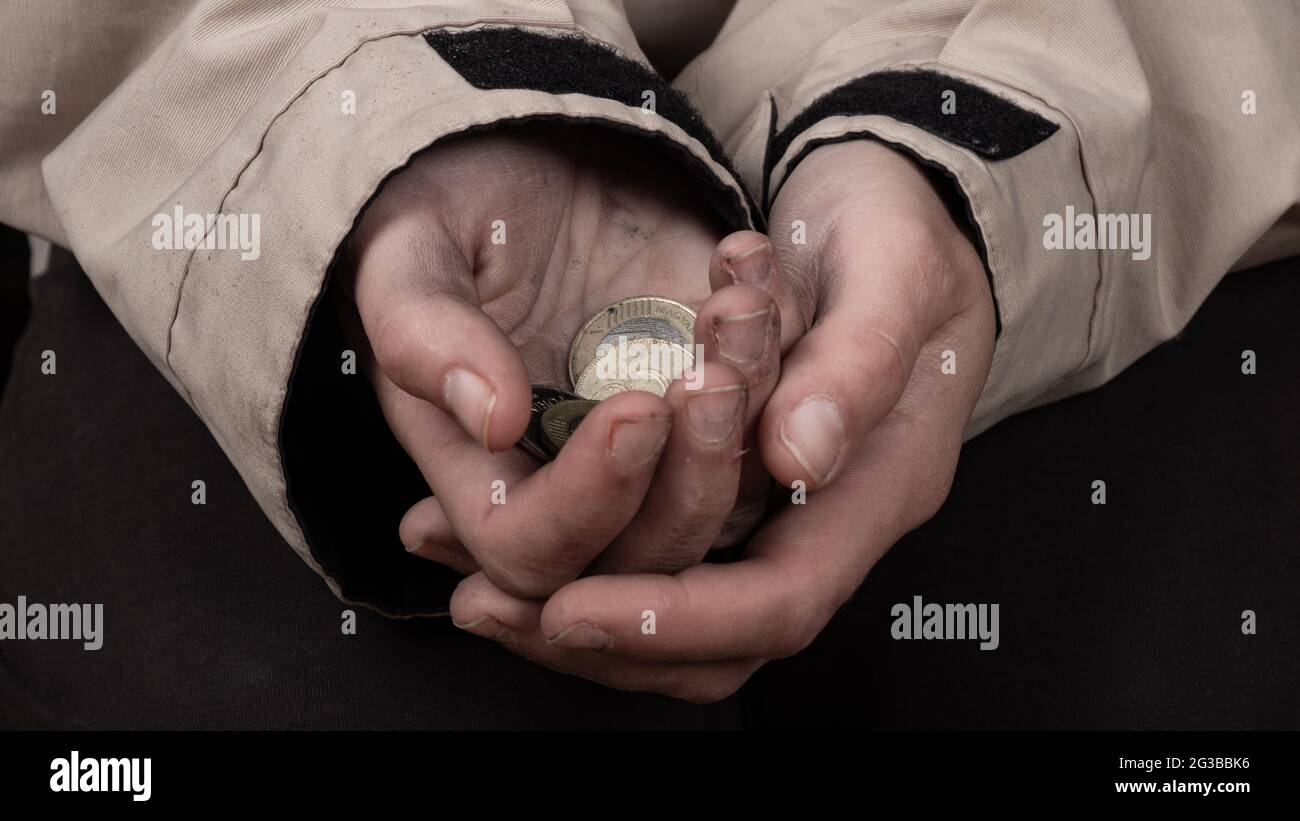 Bettler mit schmutzigen Händen bettelt um Geld, bittet um finanzielle Unterstützung. Stockfoto