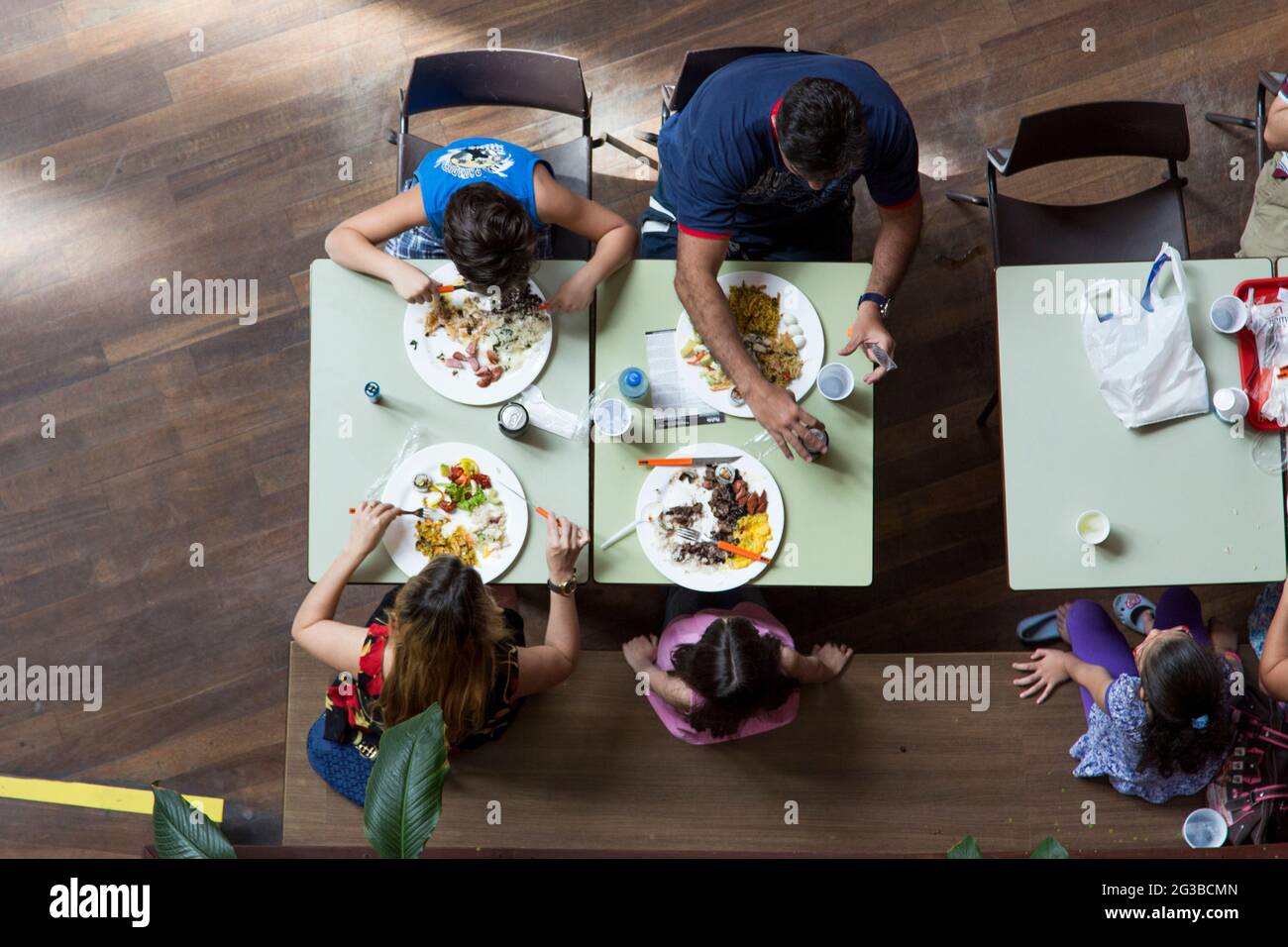 Familie, die in einem Lebensmittelbereich in einem Einkaufszentrum zu Mittag gegessen hat Stockfoto