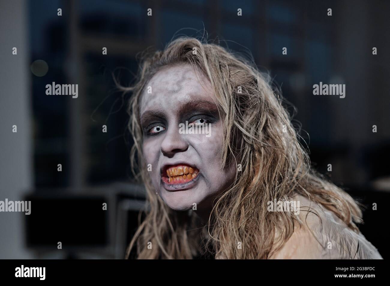 Gruselige Zombie Geschäftsfrau, die dich mit gruseligen Grinsen ansieht Stockfoto