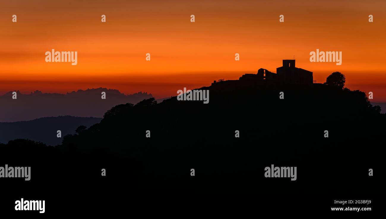 Silhouette des Berges Tagamanent und der Kirche, in Montseny, bei Sonnenuntergang (Barcelona, Vallès Oriental, Katalonien, Spanien) Stockfoto