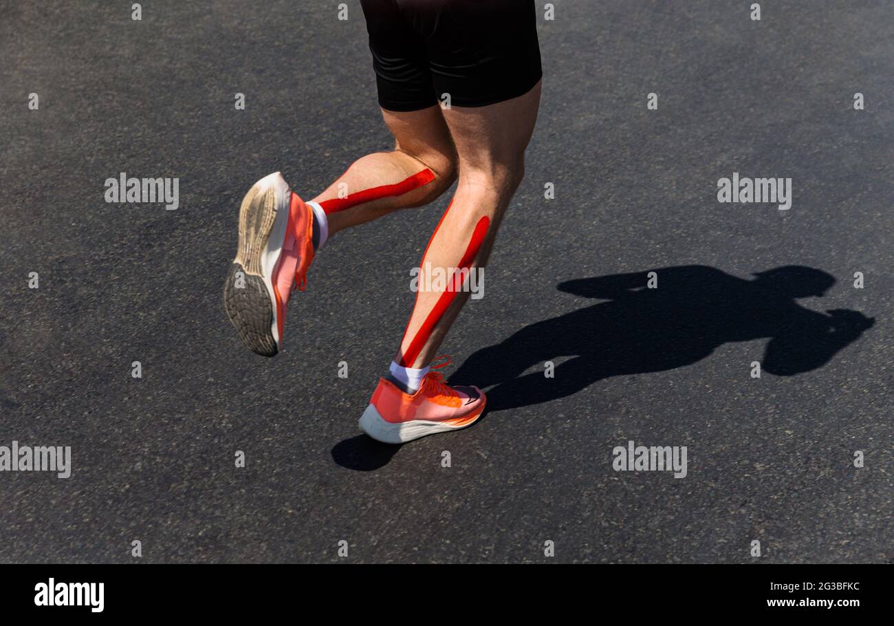 Männliche Läuferbeine auf Wadenkinesio-Aufnahmen laufen Marathon Stockfoto