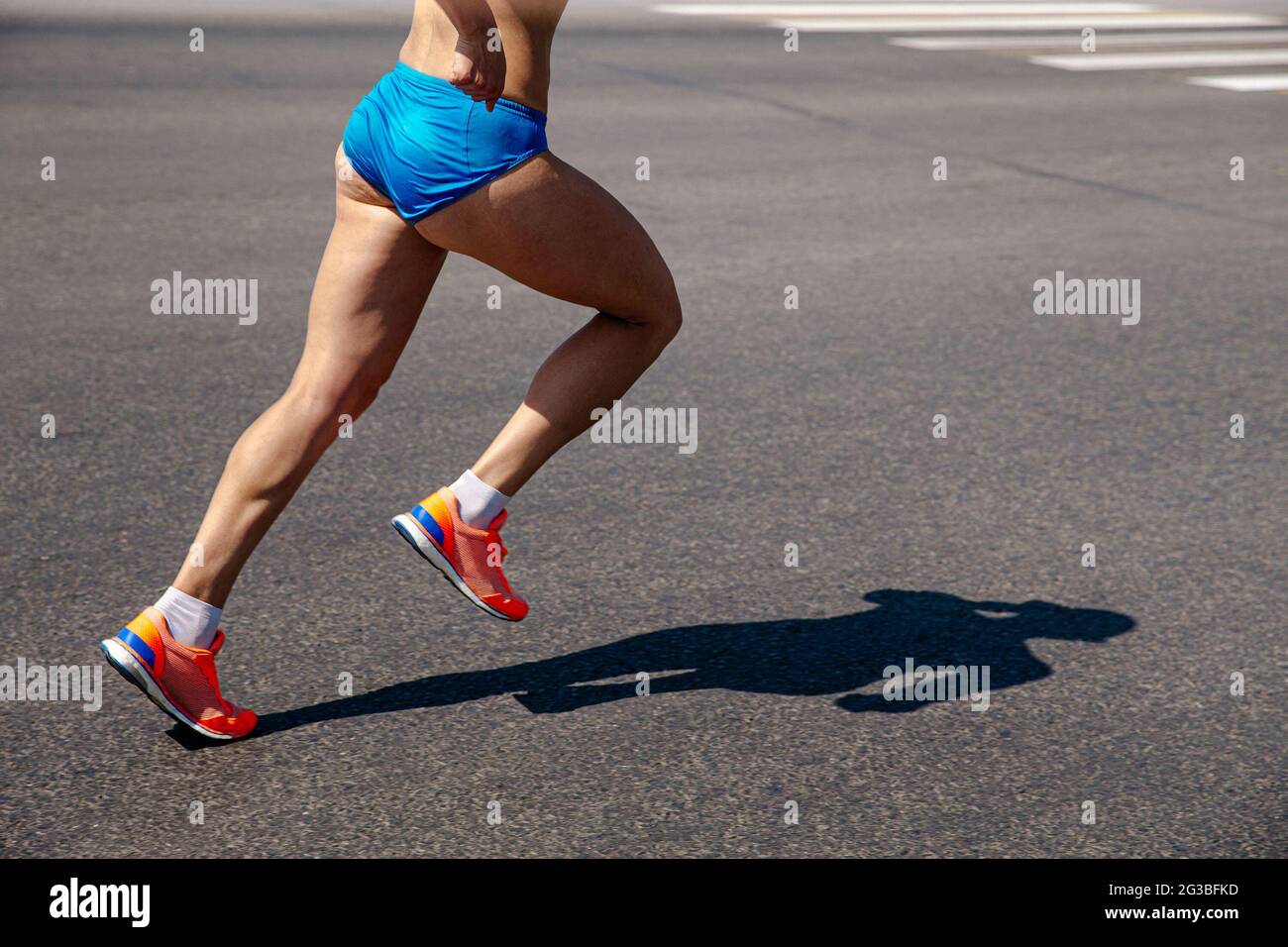 Beine weibliche Läuferin laufen auf grauem Asphalt Marathon Stockfoto
