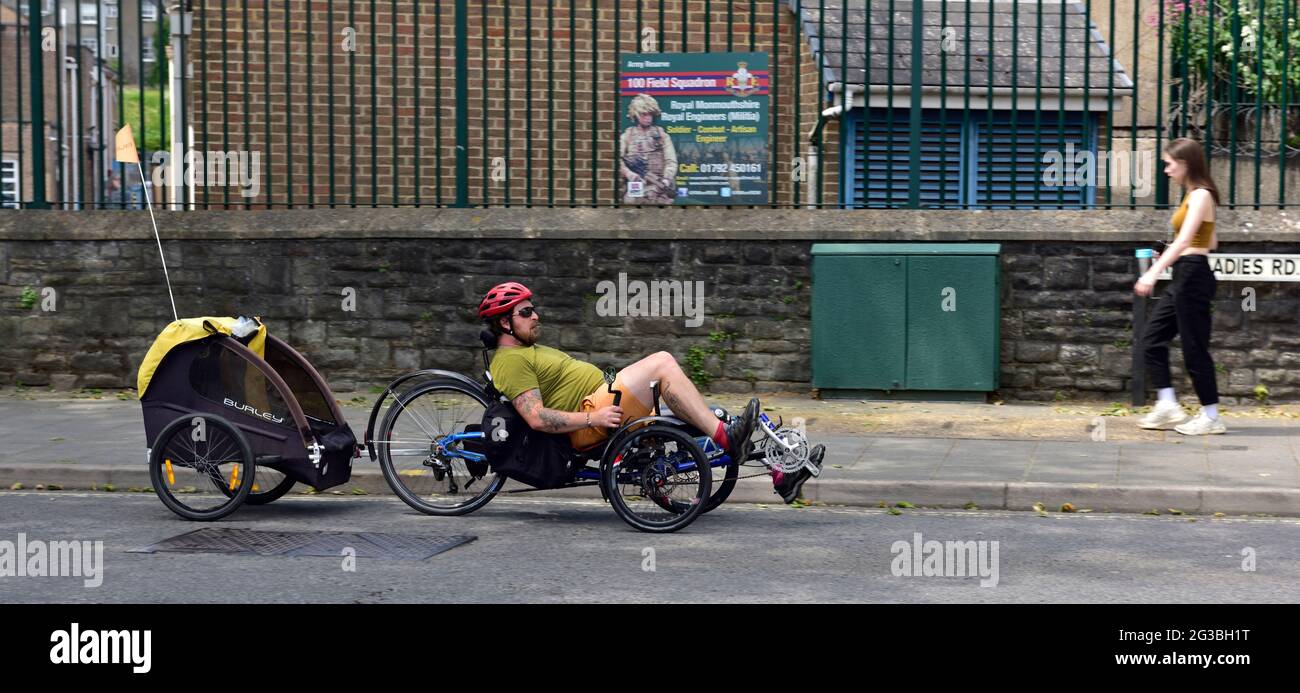 Liegerad Dreirad Radfahrer ziehen Anhänger Radfahren auf der normalen Stadtstraße, Bristol, Großbritannien Stockfoto