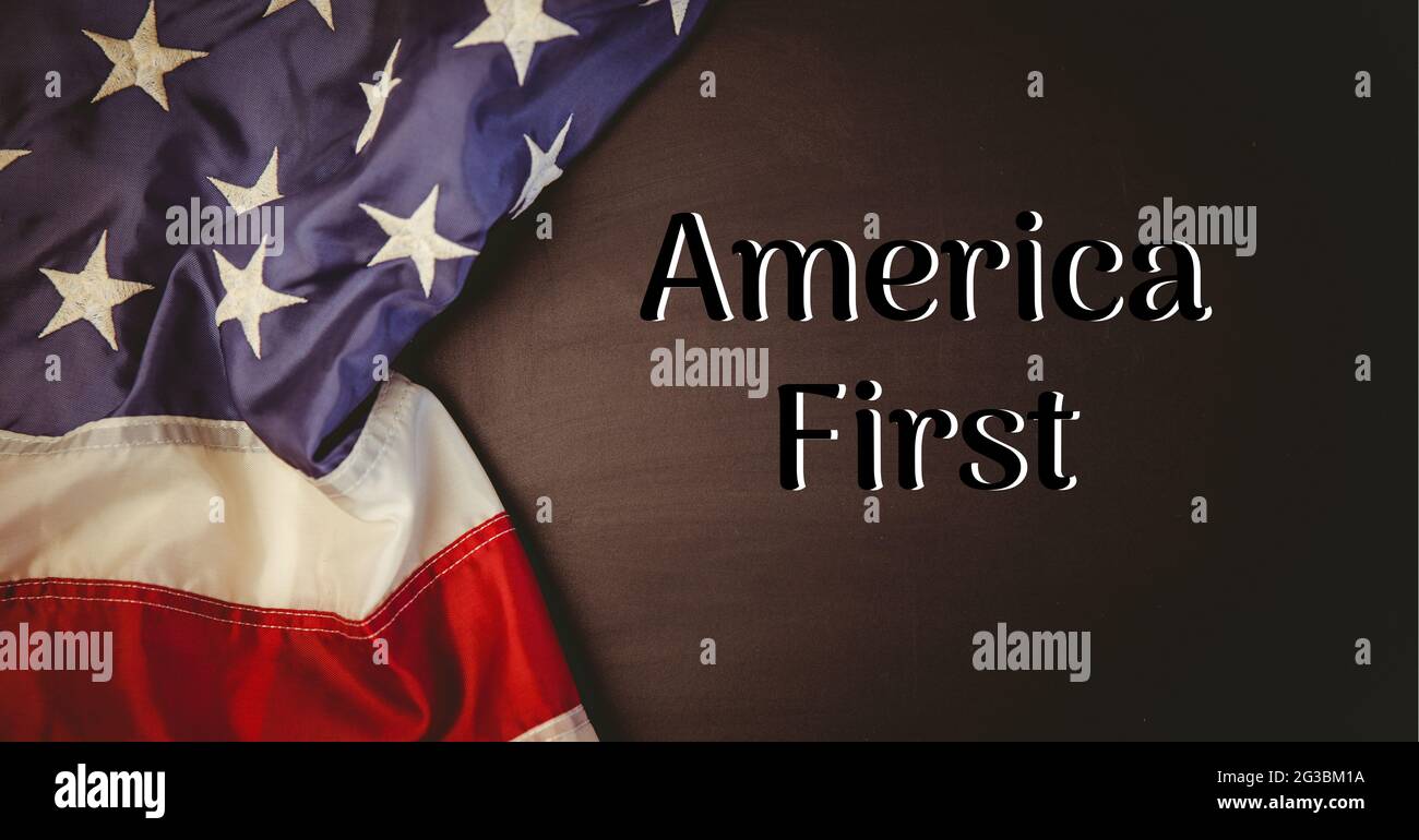 Textkomposition amerika zuerst auf dunklem Hintergrund mit amerikanischer Flagge Stockfoto