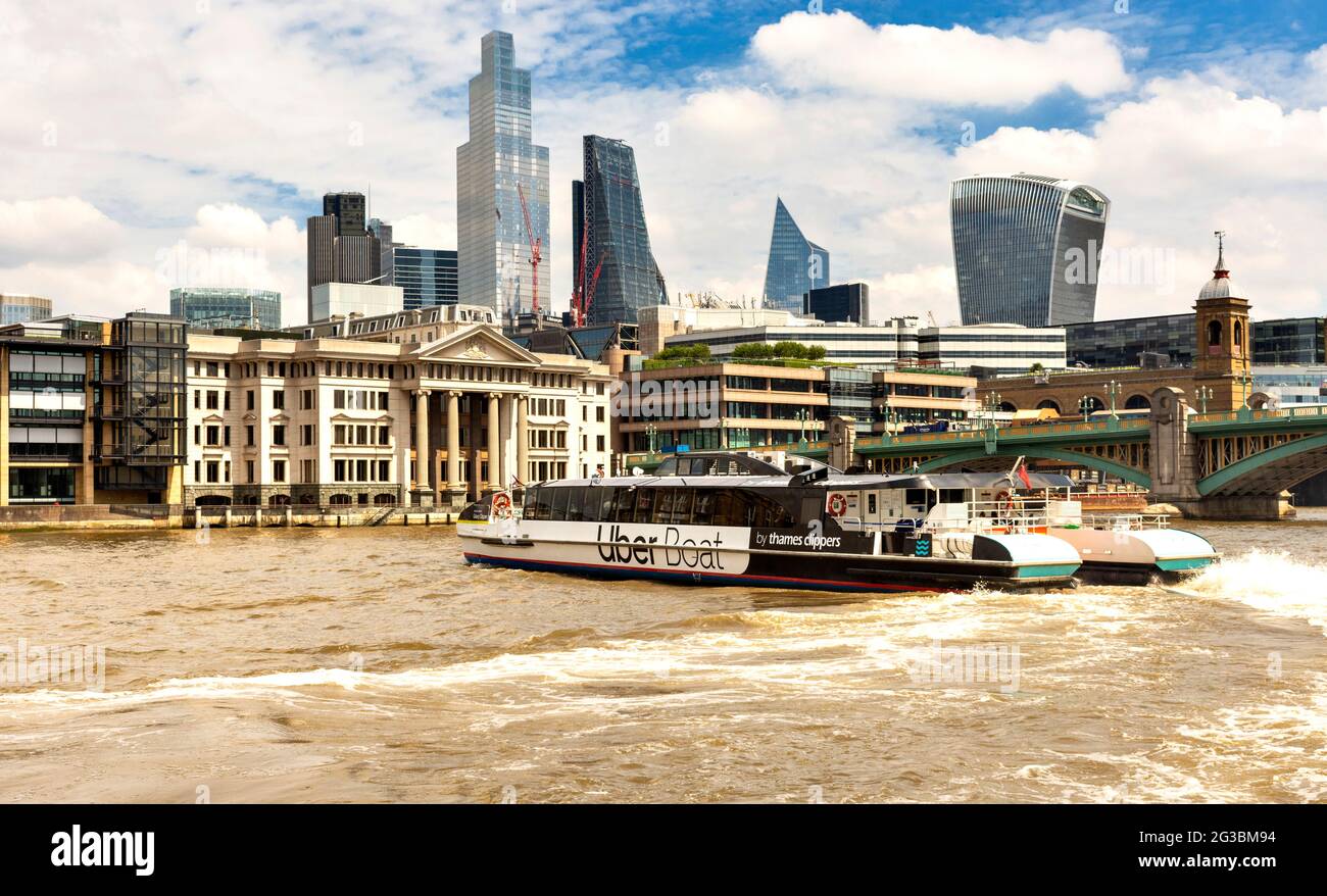 LONDON ENGLAND UBER BOOT VON THAMES CLIPPERS DREHEN AUF DER THEMSE IN DER NÄHE SOUTHWARK BRÜCKE WOLKENKRATZER IN DER FERNE Stockfoto