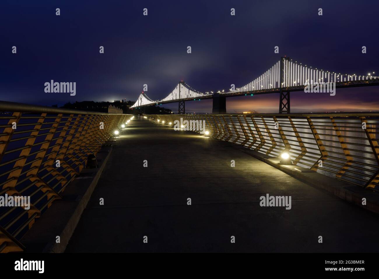 Die Bay Bridge mit Foggy Blue Skies eingerahmt von Pier 14 Railings. San Francisco, Kalifornien, USA. Stockfoto