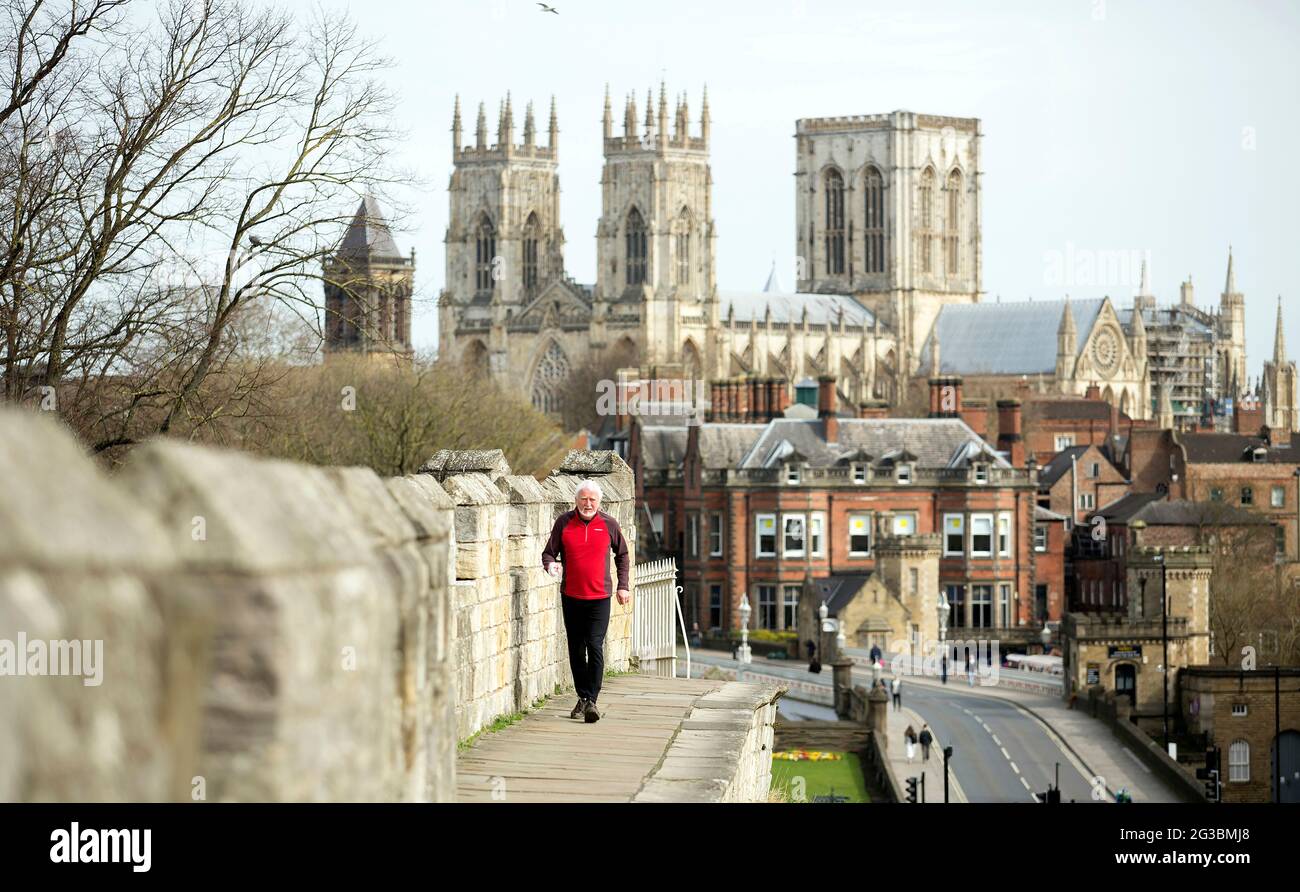 Der 74-jährige Philip Hunter joggen täglich entlang der Stadtmauern von York, um sich vor dem Hintergrund einer nahezu menschenleeren Stadt und des Yorker Münsters fit zu halten Stockfoto