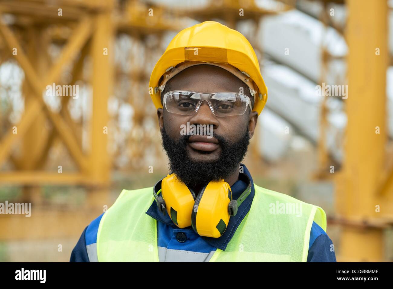 Junger afrikanischer Ingenieur in Arbeitskleidung und Schutzhelm, der dich ansieht Stockfoto