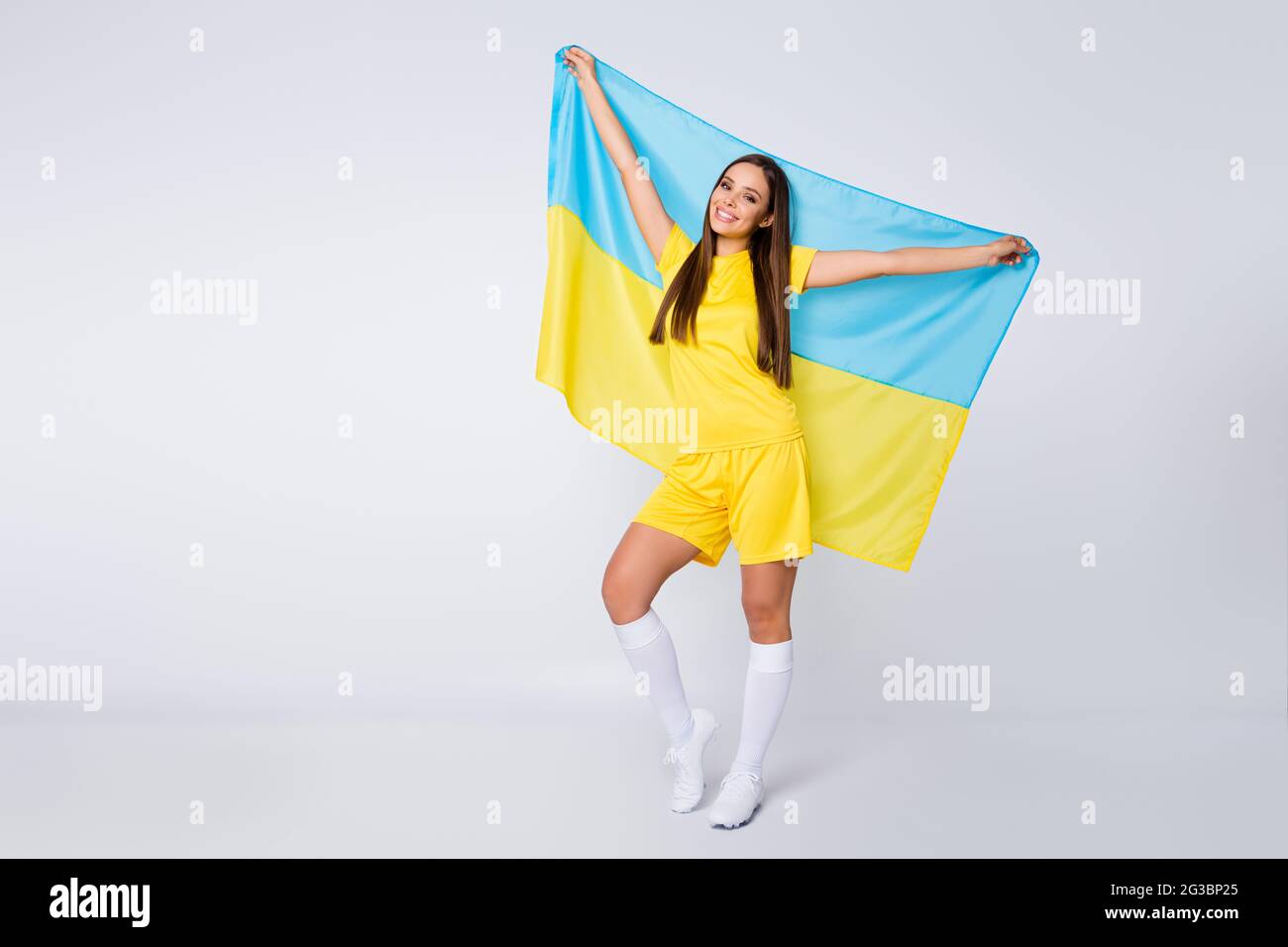 In voller Länge Körpergröße Ansicht von ihr sie schön froh fröhlich geradhaarige Mädchen Fan in den Händen halten ukrainische Flagge Feier Urlaub Stockfoto