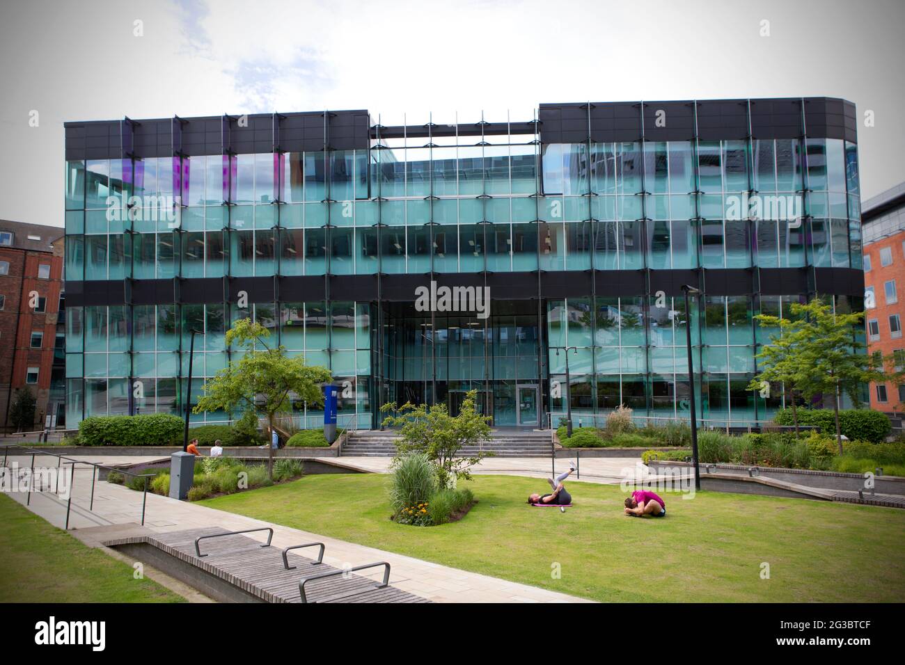 Vor den leeren Büros von KPMG auf dem Sovereign Square, einem einst geschäftigen und geschäftigen Geschäftsviertel im Stadtzentrum von Leeds, trainieren die Menschen auf dem Rasen. Leeds Stockfoto