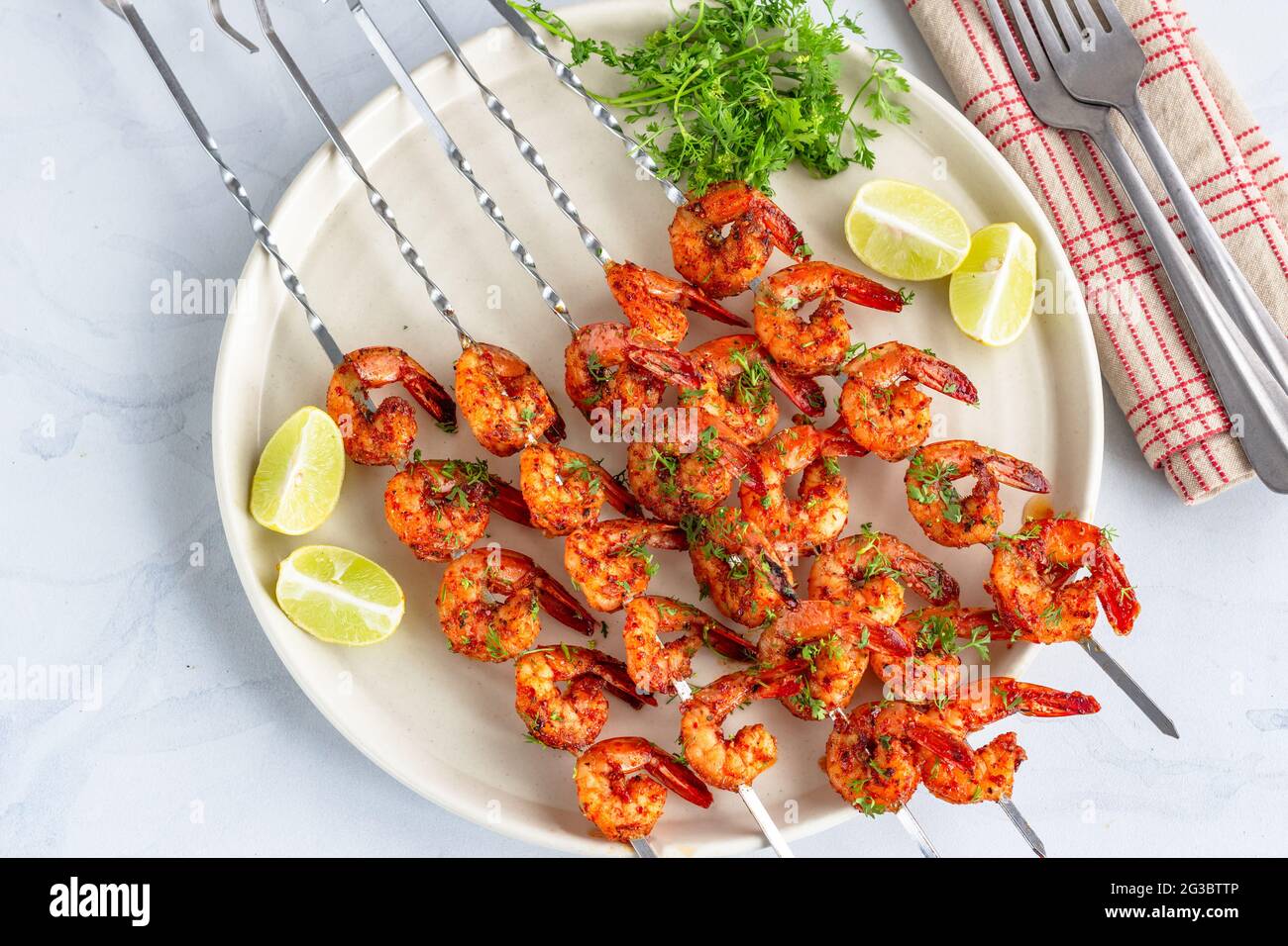 Gegrillte Garnelenspieße auf einem Gericht garniert mit Cilantro und Lemon Top Down Photo Stockfoto