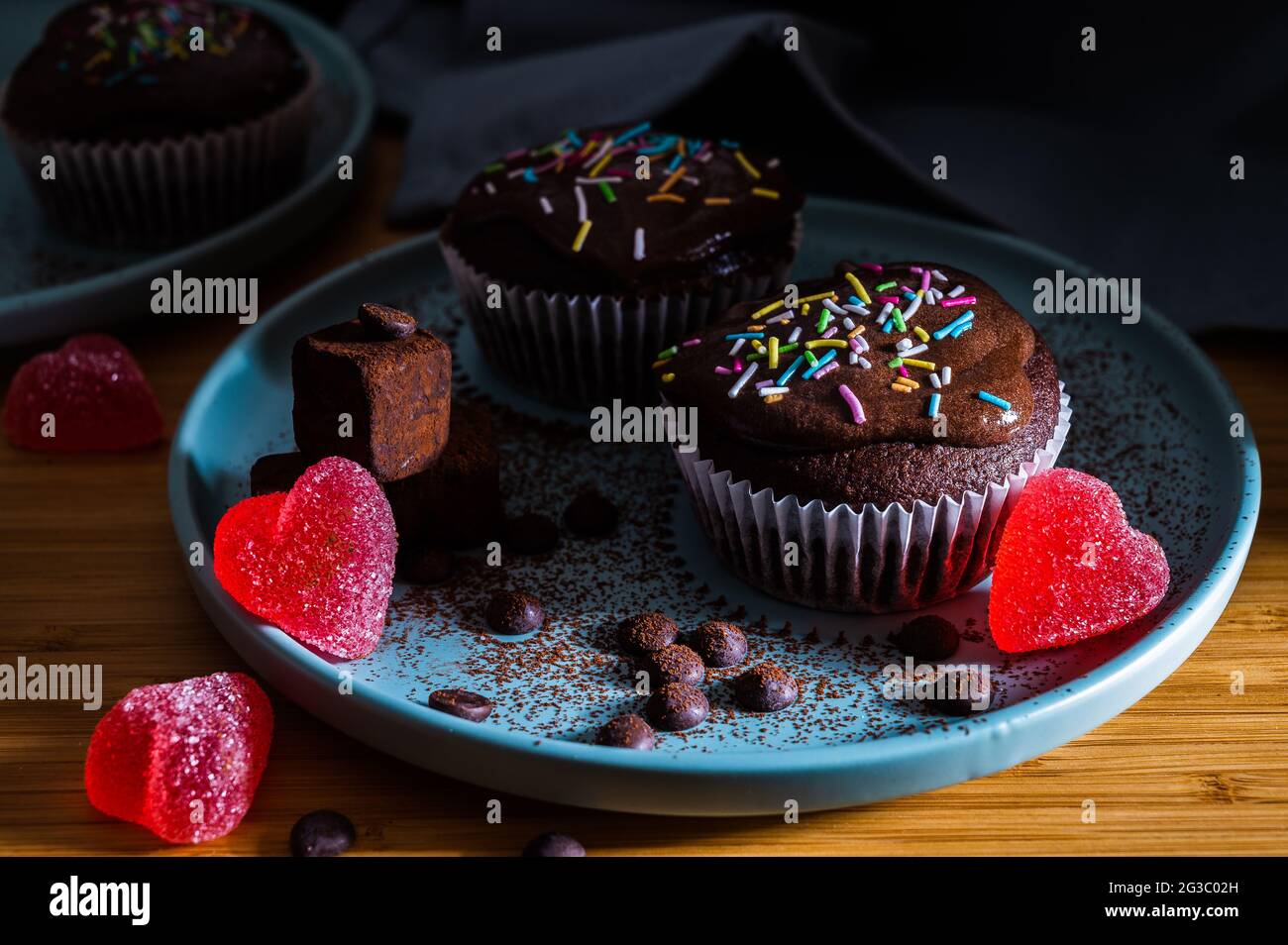 Valentinstag Cupcake. Leckere Cupcakes aus Schokolade mit Creme und farbigen Streuseln. Süßer, köstlicher Desserttrüffel und herzförmige Süßigkeiten auf einem Teller. D Stockfoto
