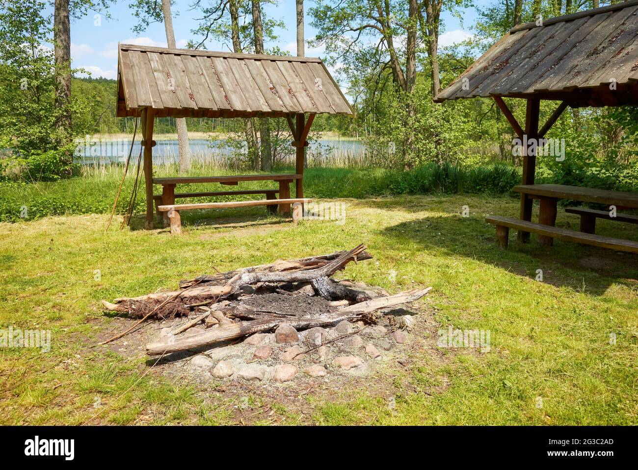 Lagerfeuer und Picknickplatz in einem Wald an einem See. Stockfoto
