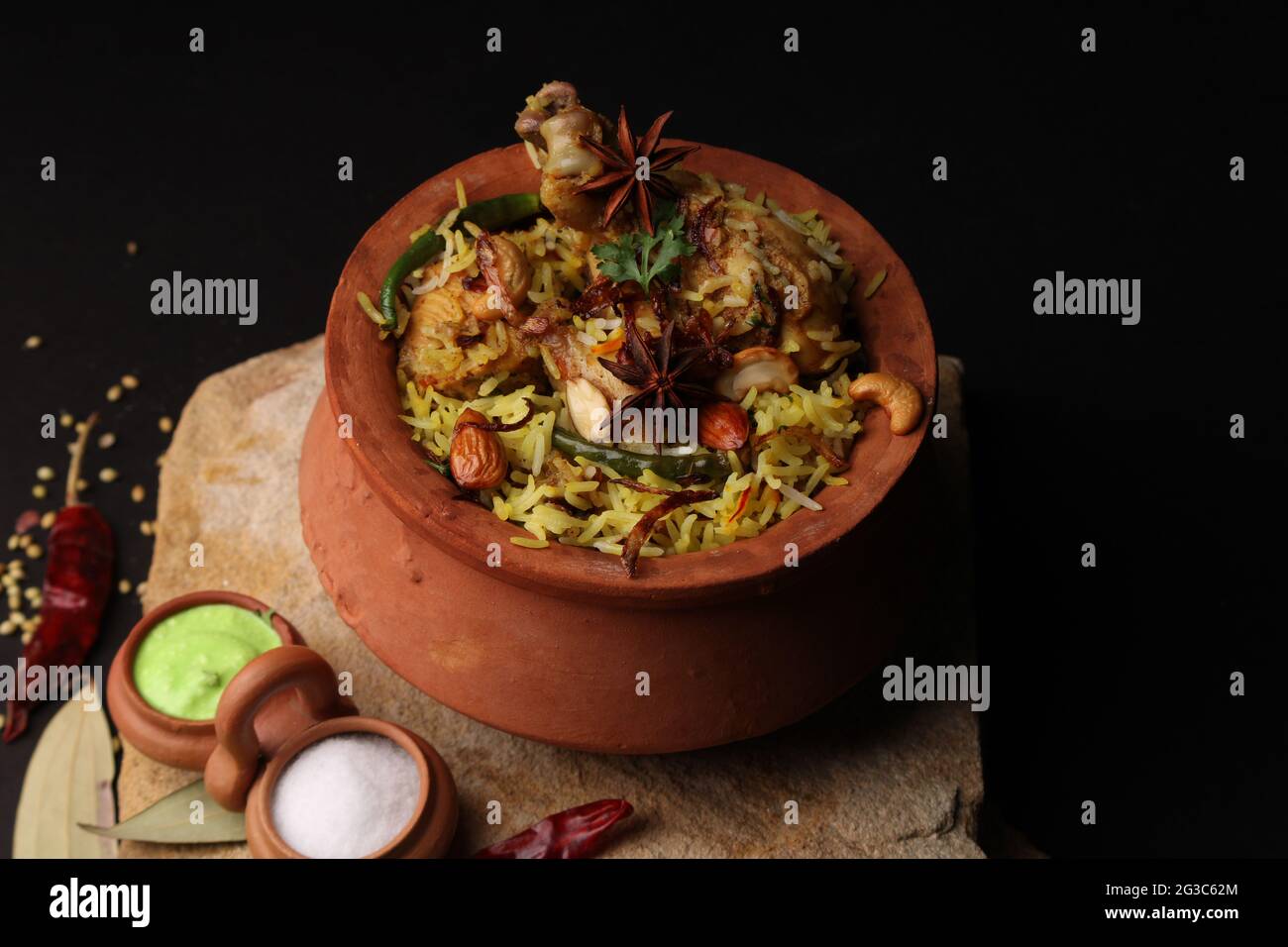 Würziges Hähnchen Dum biryani in traditionellem Handi- oder Tontopf. Serviert mit Zwiebelraita Stockfoto