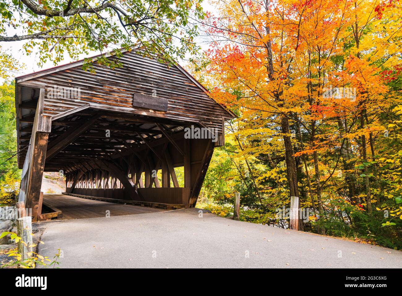 Verlassene historische hölzerne überdachte Brücke in New Hampshire an einem sonnigen Herbsttag. Atemberaubende Herbstfarben. Stockfoto