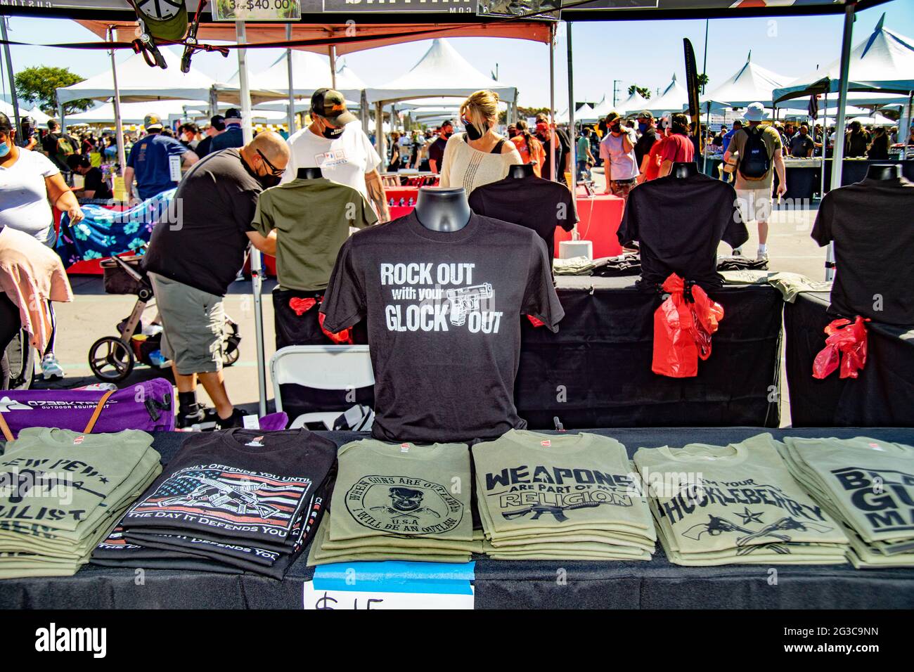 T-Shirts für rechtsextreme Politik und Waffenbegeisterung stehen auf einer Waffenmesse im Freien in Costa Mesa, CA, zum Verkauf. Beachten Sie die Maske aufgrund des Coronavirus pande Stockfoto