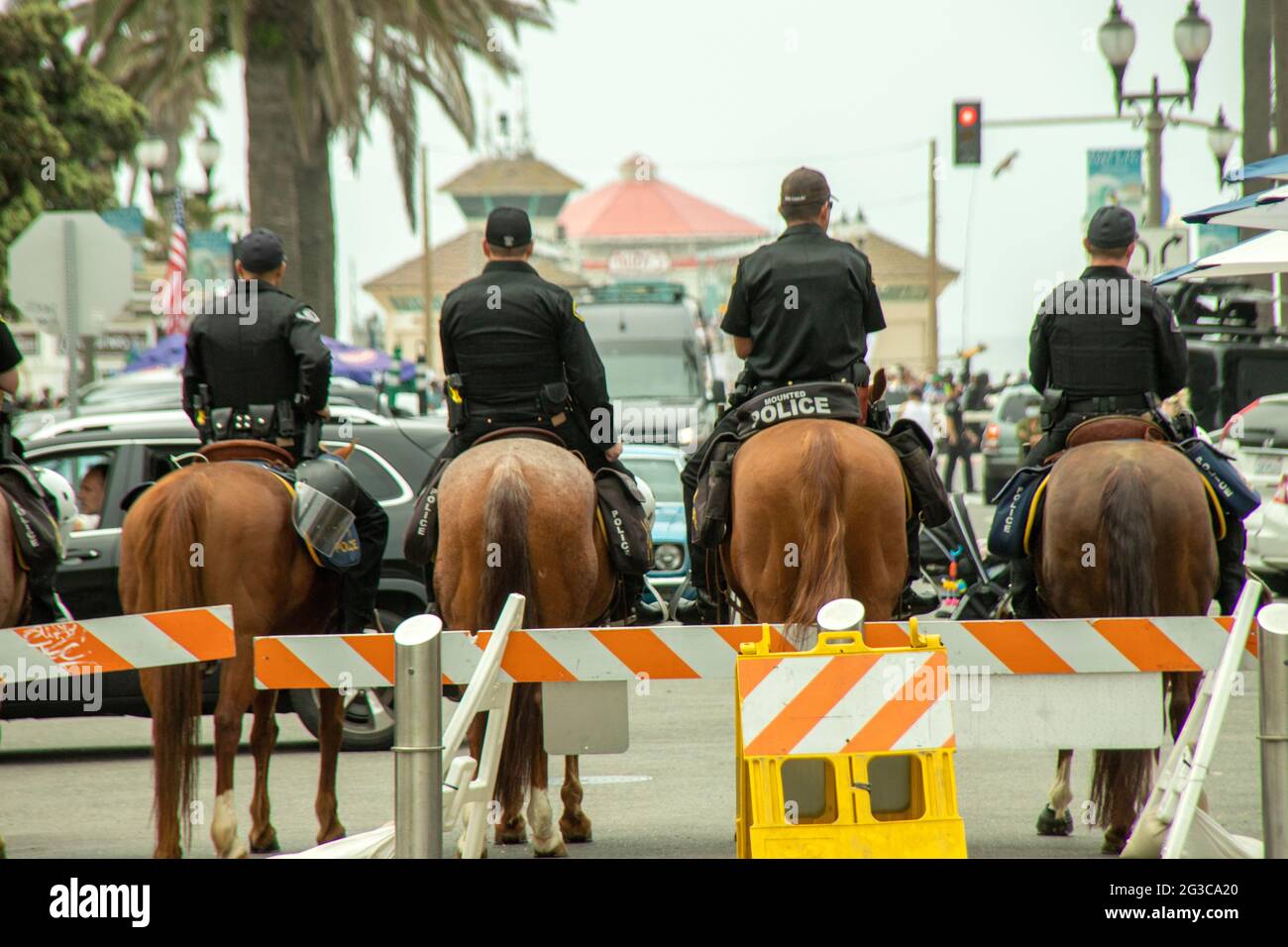 Berittene Polizisten kommen in Huntington Beach, CA, zur Massenkontrolle bei einer geplanten politischen Demonstration an. Stockfoto