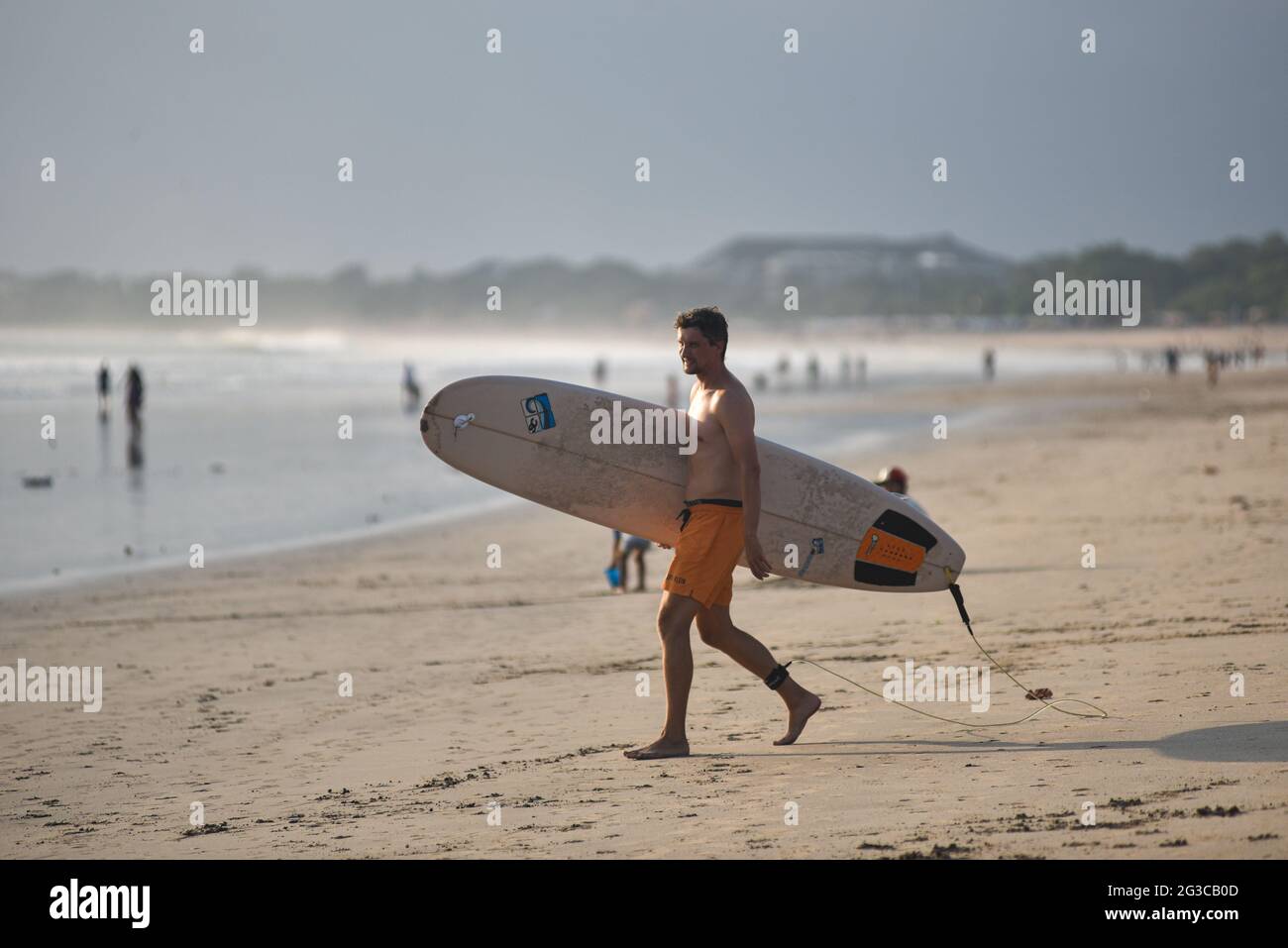 Badung, Indonesien. Juni 2021. Ein Surfer sah mit seinem Surfbrett am Strand spazieren gehen. Bali als eines der weltweiten Tourismusziele schloss seinen internationalen Tourismus seit dem Ausbruch von Covid-19 im Jahr 2020 und bereitet sich nun darauf vor, im Juli 2021 wieder für Touristen geöffnet zu werden. Kredit: SOPA Images Limited/Alamy Live Nachrichten Stockfoto