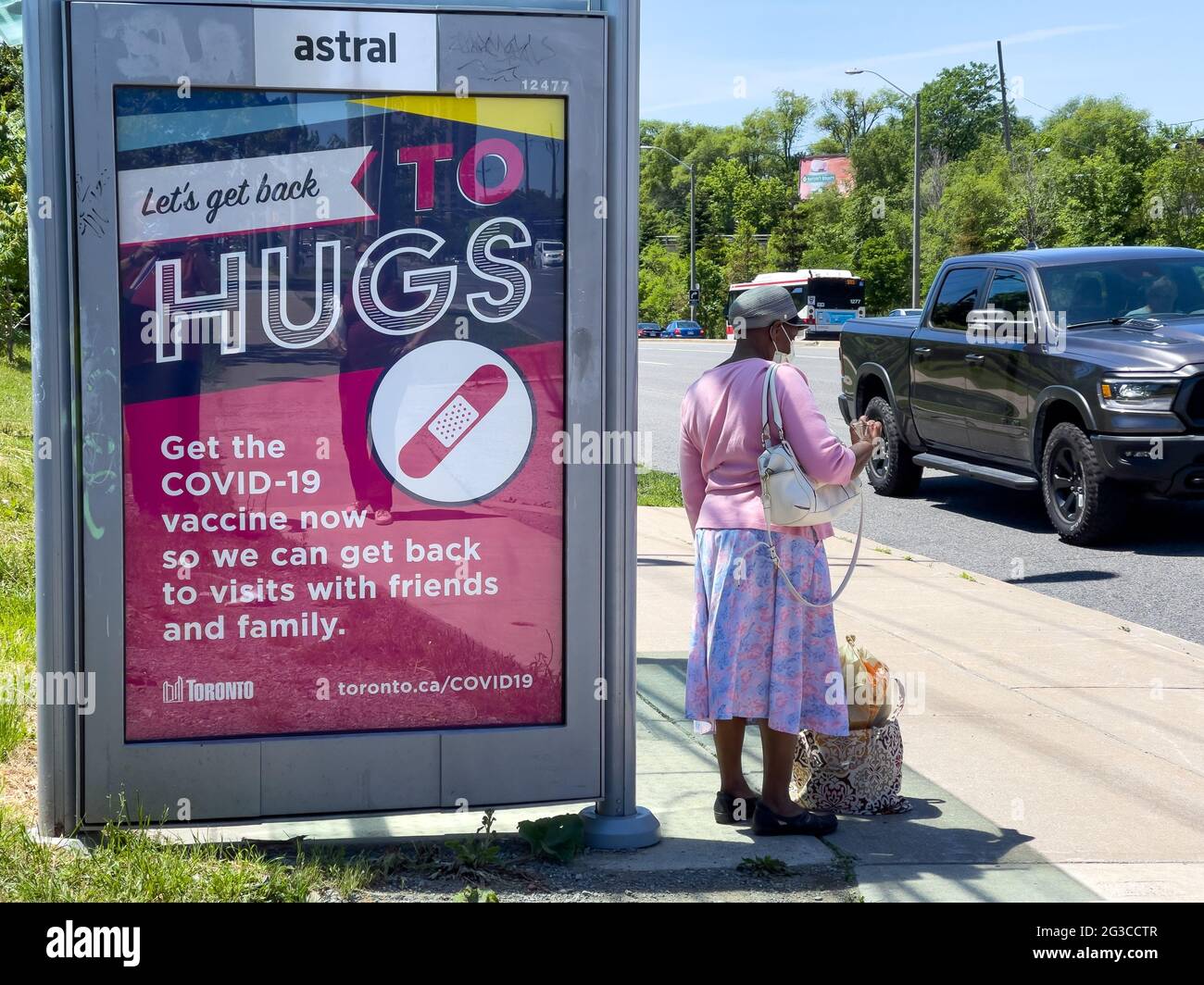 Werbezeichen der Covid-19-Impfkampagne in einem TTC-Bus in Toronto, Kanada. Es steht „Let's Get Back to Hugs“ Stockfoto