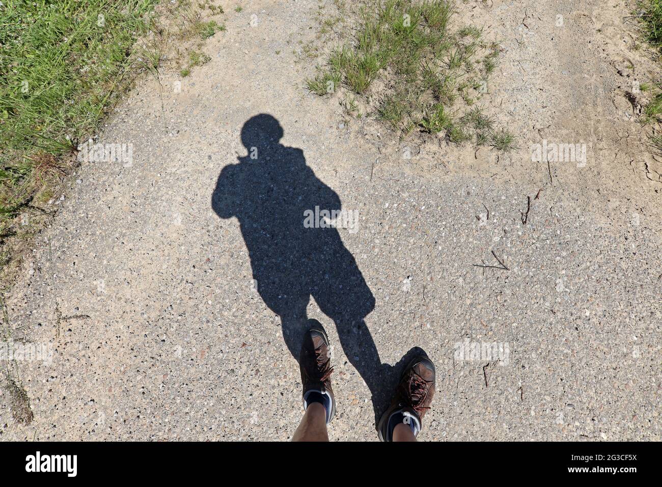 Der Schatten eines Mannes, der auf dem Bürgersteig steht. Stockfoto