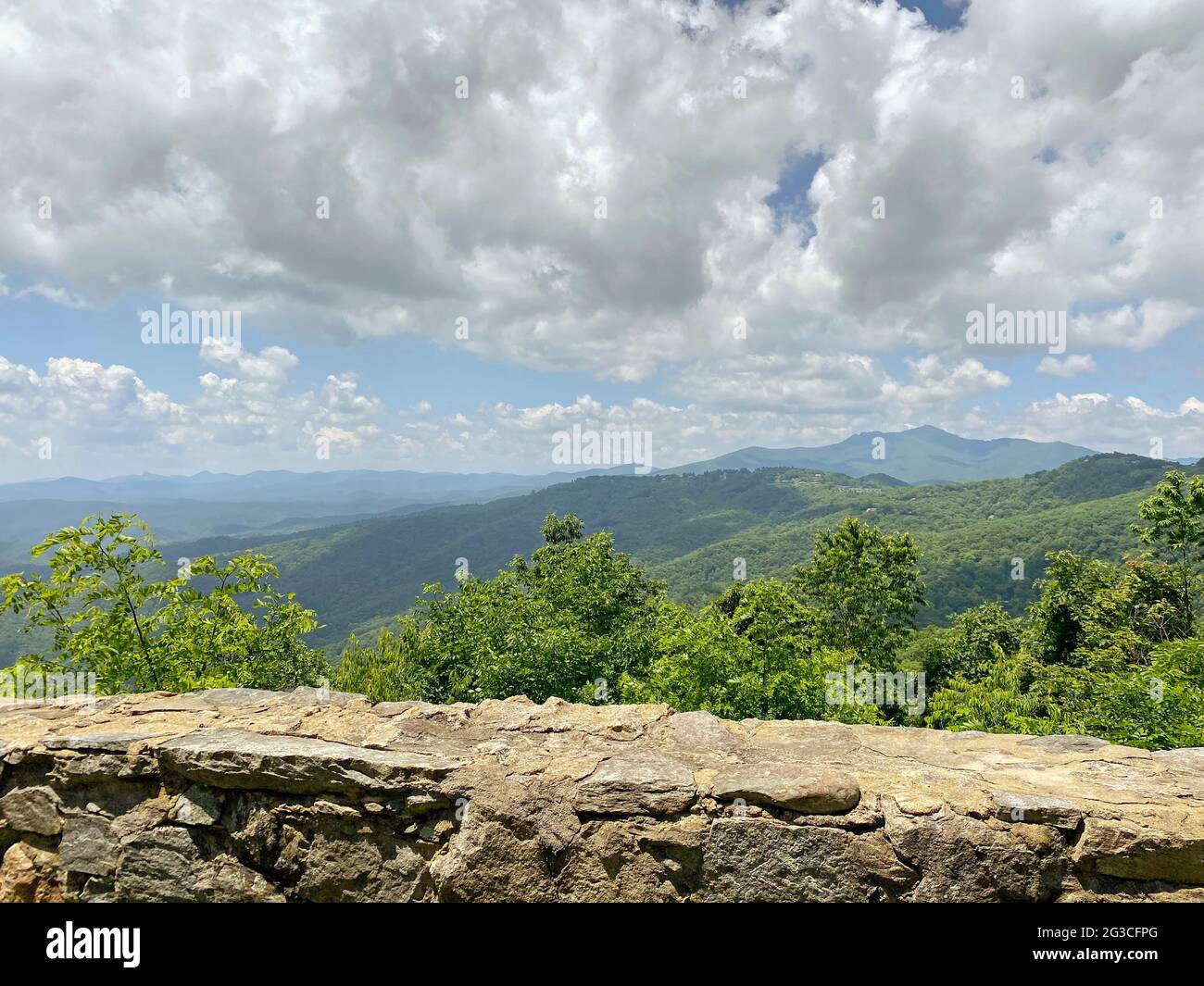 Blick auf Berge, Bäume und Wolken, von einem künstlichen Steinvorsprung aus gesehen Stockfoto