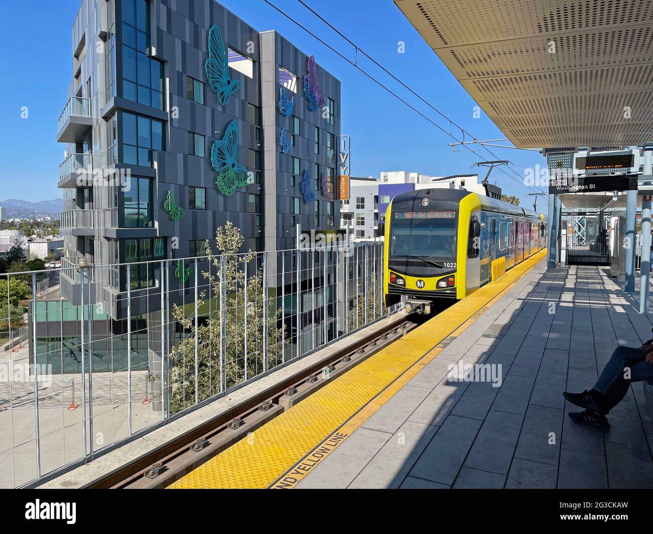 Ein U-Bahn-Zug fährt am Bahnhof Culver City in der Nähe neuer Apartmentgebäude in Los Angeles, CA, an Stockfoto