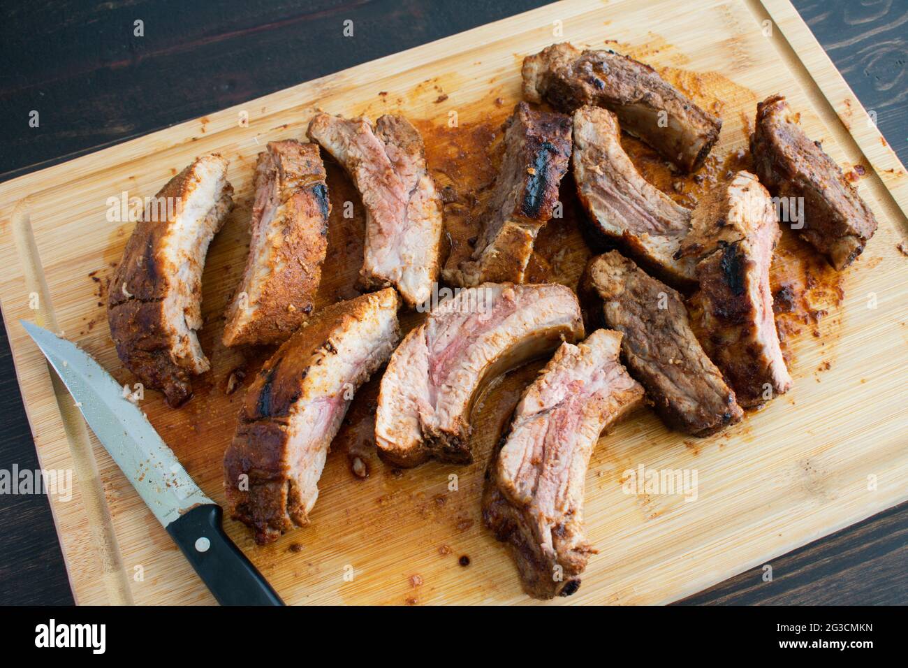 Barbecue Baby Back Ribs auf einem Bambus Schneidebrett: Schweinerippen auf einem hölzernen Schnitzbrett Stockfoto