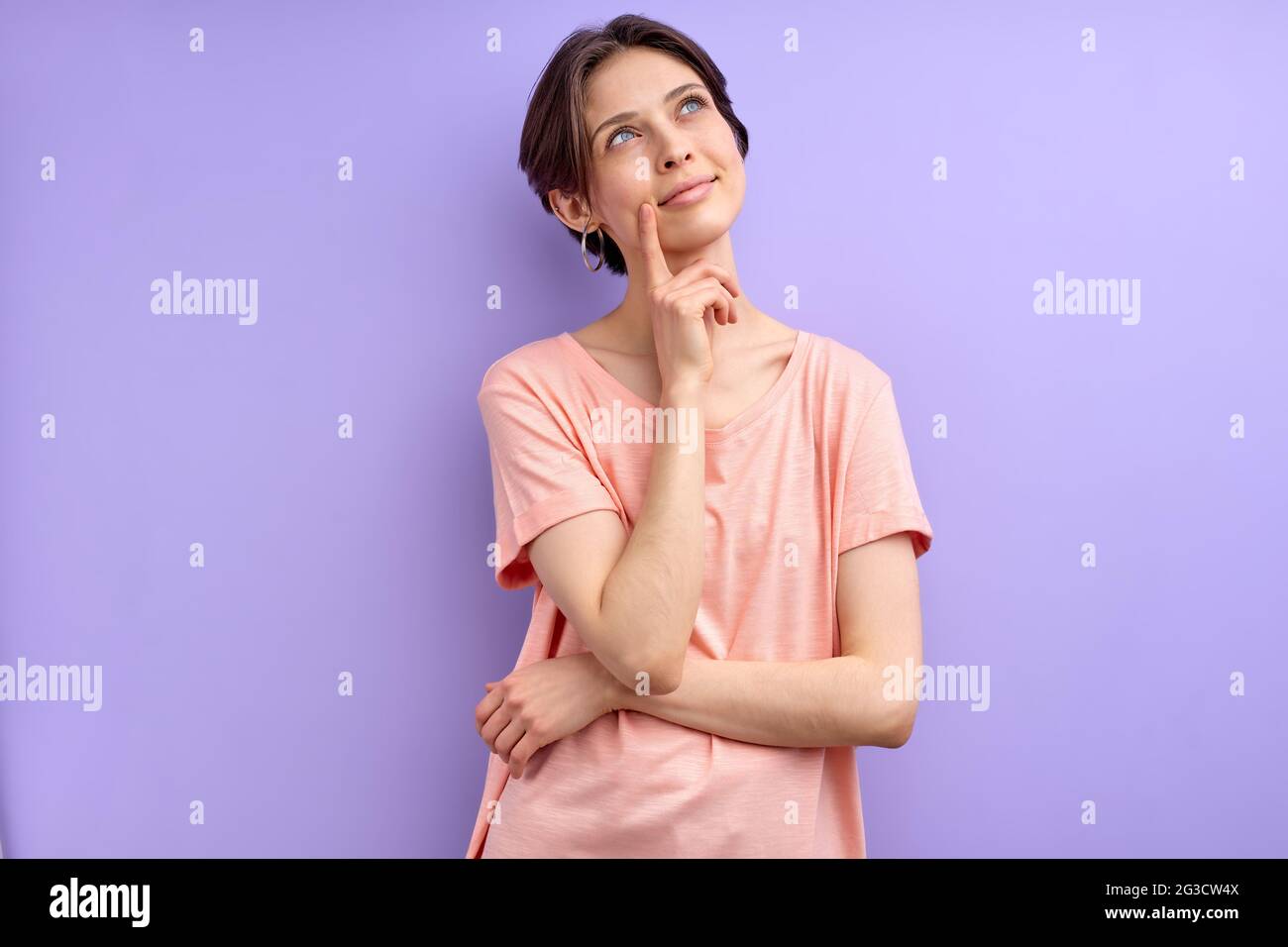 Junge Frau Denkt Über Etwas, Kommen Sie Mit Einer Idee , Kurzhaarige Dame In Casual Tragen In Kontemplation, Halten Finger Auf Chin Stockfoto