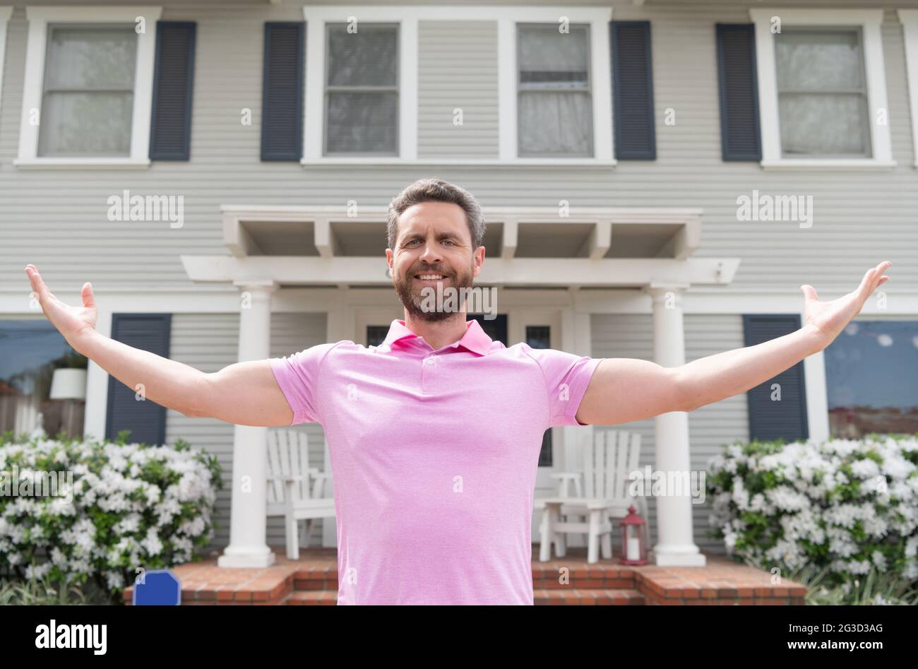 Glücklicher bärtiger Mann Besitzer in der Nähe eines neuen Hauses nach der Miete oder Kauf eines neuen Hauses, Eigentum Stockfoto