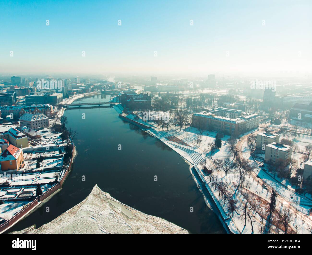 Wroclaw, Poland 02.15.2021 - Luftaufnahme der Altstadt und der Dominsel. Odra River an einem hellen sonnigen Tag während der Wintersaison. Immergrüne Bäume auf einer verschneiten Landschaft. Malerischer blauer Himmel im Hintergrund. Stockfoto