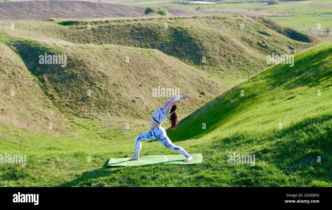Frau, die im Sommer im Freien Yoga in Sportkleidung macht Stockfoto