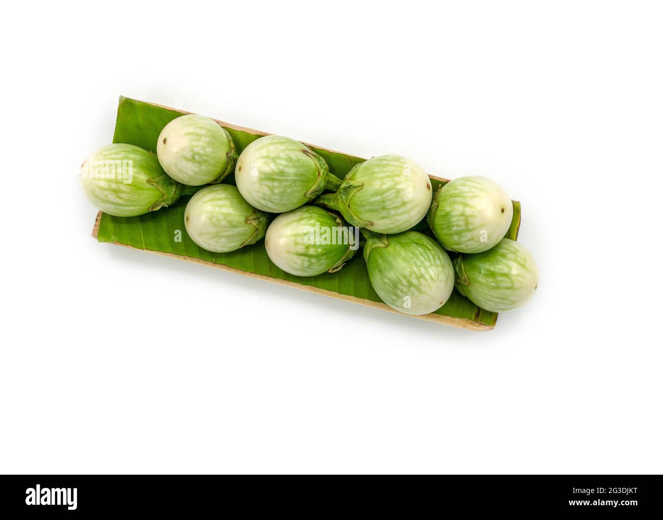 Frische thailändische Auberginen auf einem Bananenblatt mit einem Tablett, das aus einer Banane hergestellt wurde, das Bild auf weißem Hintergrund, Draufsicht thailändische Auberginen. Stockfoto