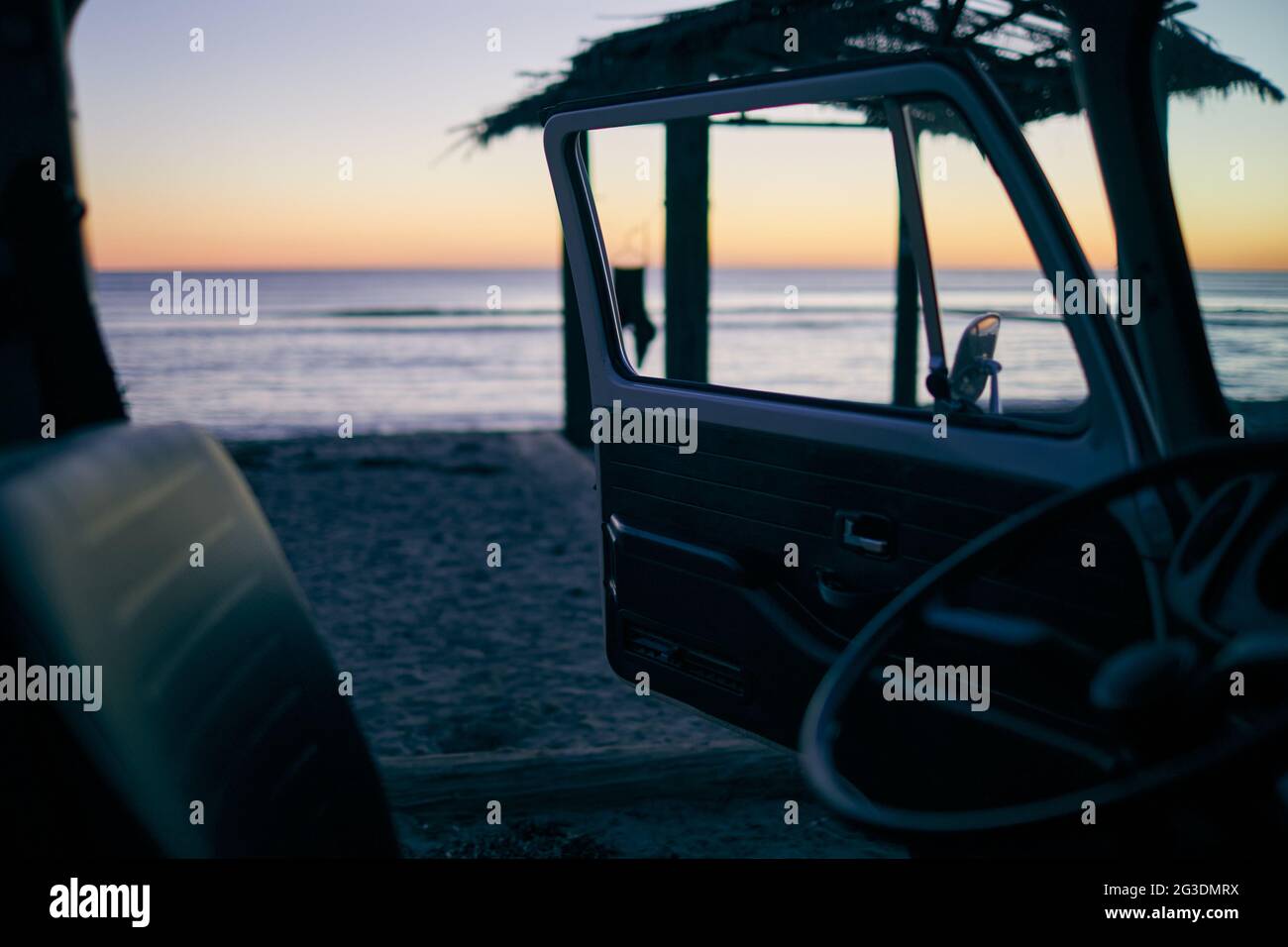 VW Bus sitzt am Strand bei Sonnenuntergang in San Clemente Kalifornien Stockfoto