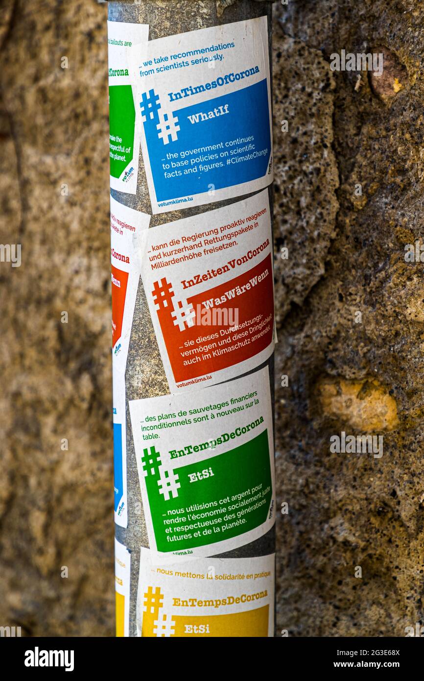 Viersprachiger Aufkleber auf einem Lampenpfosten in Luxemburg: "In Zeiten von Corona nehmen wir Empfehlungen von Wissenschaftlern ernst. Was ist, wenn die Regierung weiterhin auf wissenschaftlichen Fakten und Zahlen setzt?“ Stockfoto