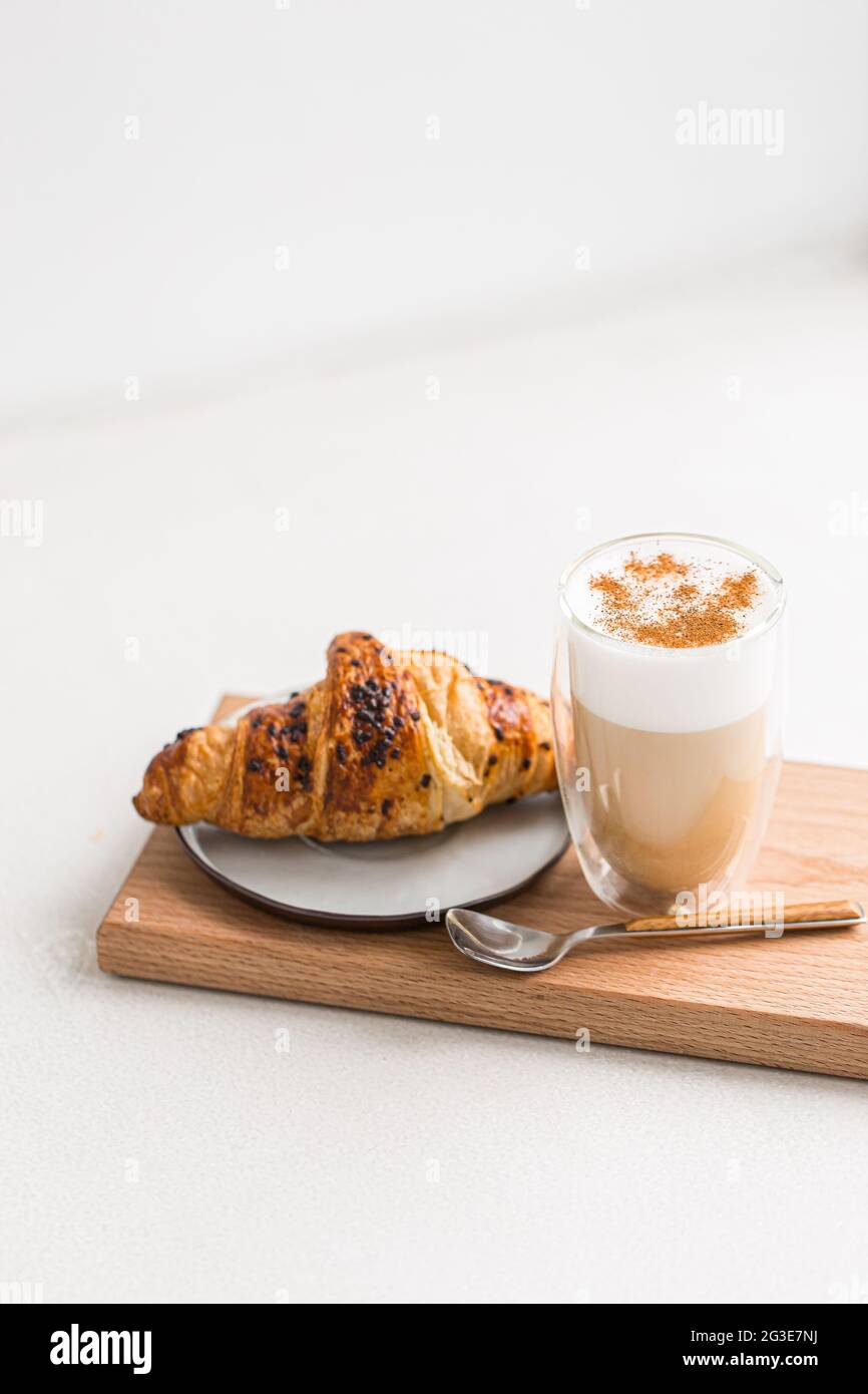 Glas Kaffee Latte mit Zimt und Croissant Stockfoto