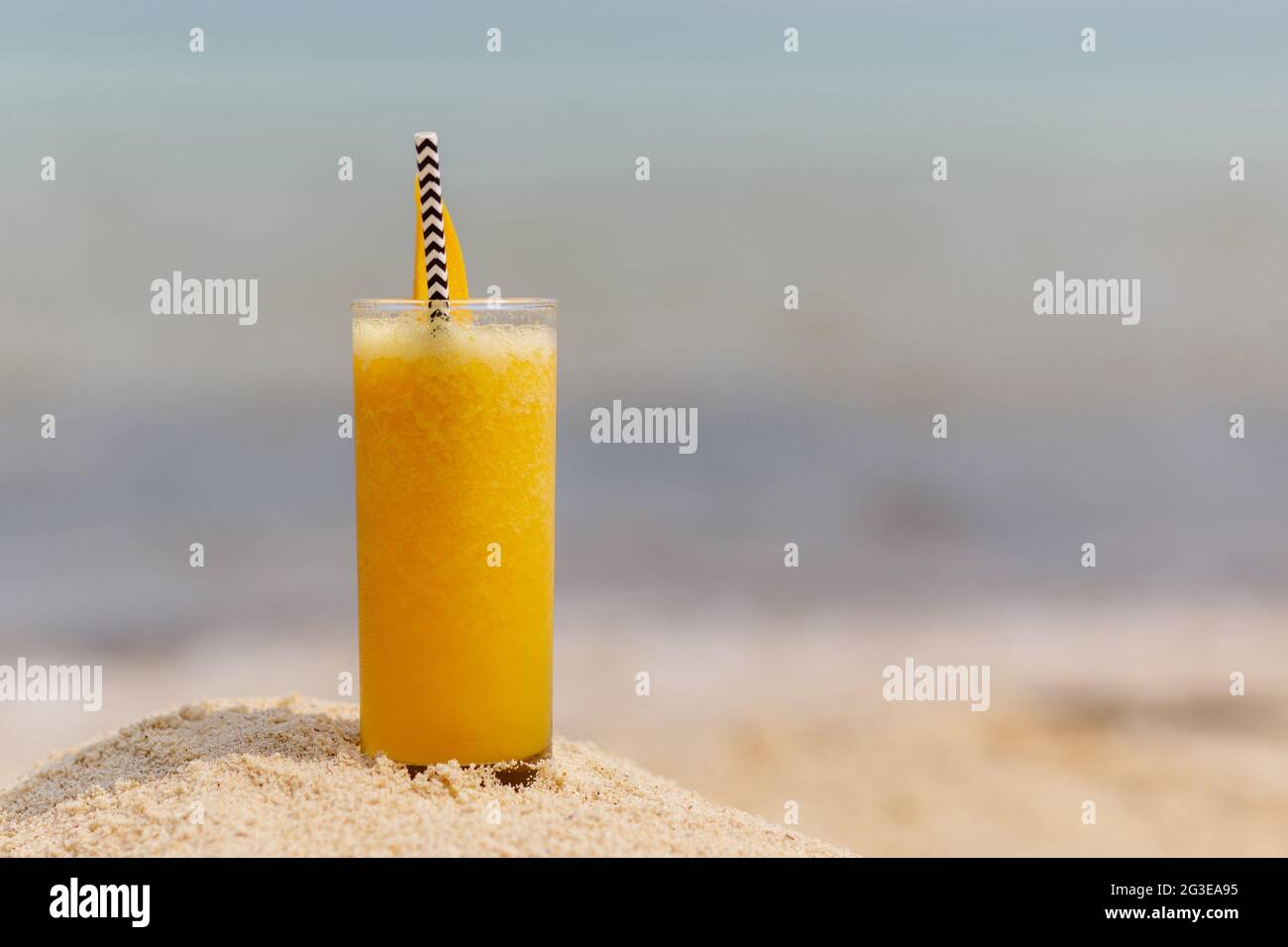 Frucht-Mango-Cocktail im Hintergrund des Strandes Stockfoto