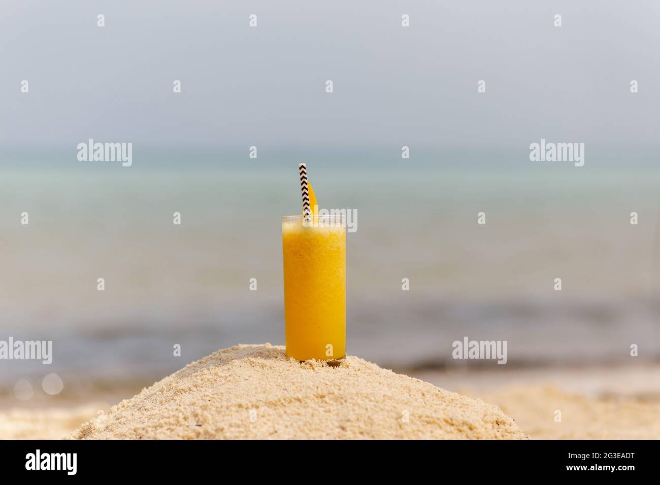 Frucht-Mango-Cocktail im Hintergrund des Strandes Stockfoto