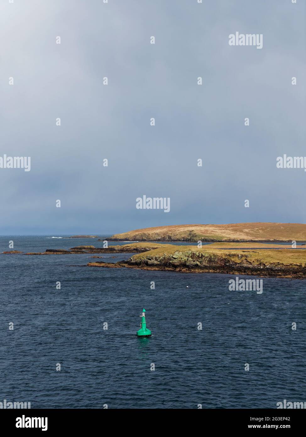 Eine grüne Schifffahrtsboje mit Solarpanel im Shetland-Sound nähert sich an einem Winters-Tag im Norden mit einem Squall. Stockfoto