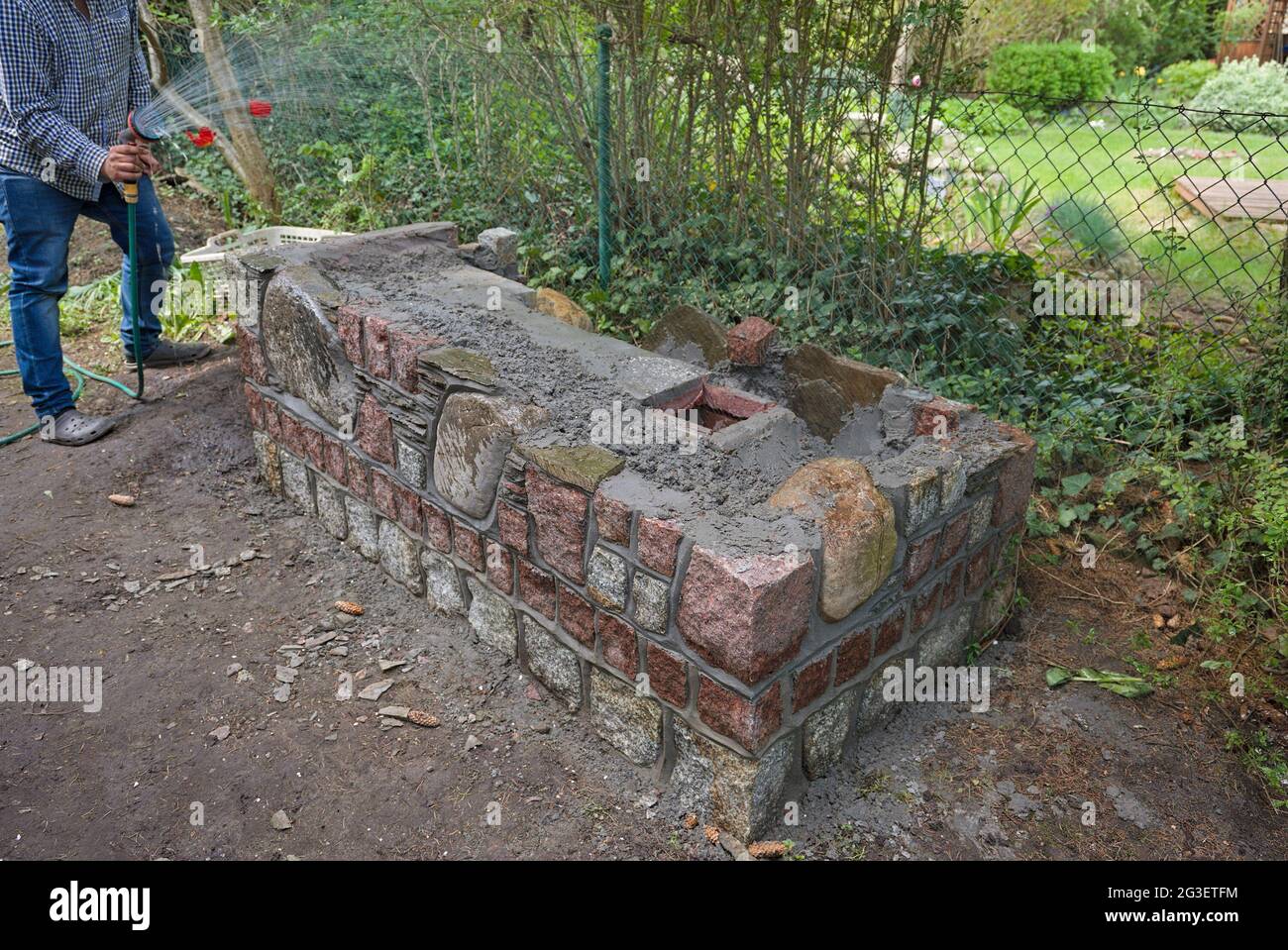 Wasserangel auf Beton beim Bau des Rauchens im Garten eines Landhauses Stockfoto