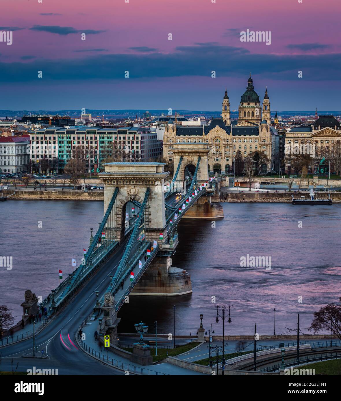 Budapest, Ungarn - die berühmte Szechenyi Kettenbrücke (Lanchid) bei Sonnenuntergang mit Nationalflaggen geschmückt, die den 15. März 1848 bürgerrevolt feiern Stockfoto