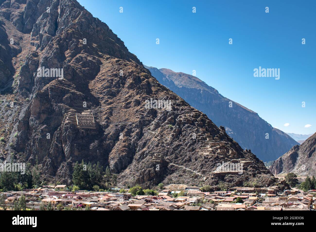 Blick über die Stadt Ollantaytambo auf die archäologische Stätte Pinkuylluna mit Perus heiligem Tal im Hintergrund Stockfoto