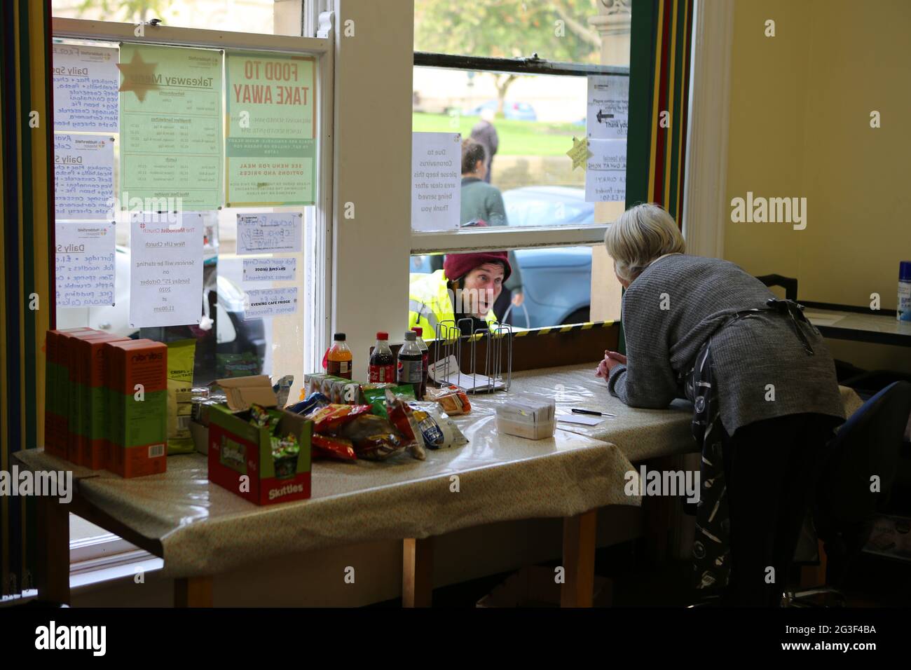 Kath Brown, eine Pflegeassistentin, spricht mit einem Mann durch die Servierluke, der im Mis kostenlose warme Speisen und heiße Getränke an bedürftige Einheimische serviert Stockfoto