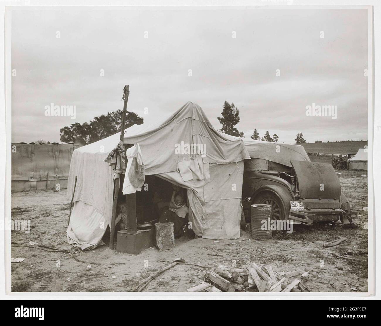 Cotton Pickers’ Camp, Nipomo California. Ein junger Baumwollpflücker in den düsteren Jahren der Großen Depression. Lange war ursprünglich ein Porträtfotograf, wie man sehen kann. In den 1930er Jahren zeichnete sie die Arbeits- und Lebensbedingungen im ländlichen Amerika für die Farm Security Administration auf. Auf der Suche nach Arbeit wanderten ganze Familien im ganzen Land aus und lebten in Zelten, Hütten und Autos. Stockfoto