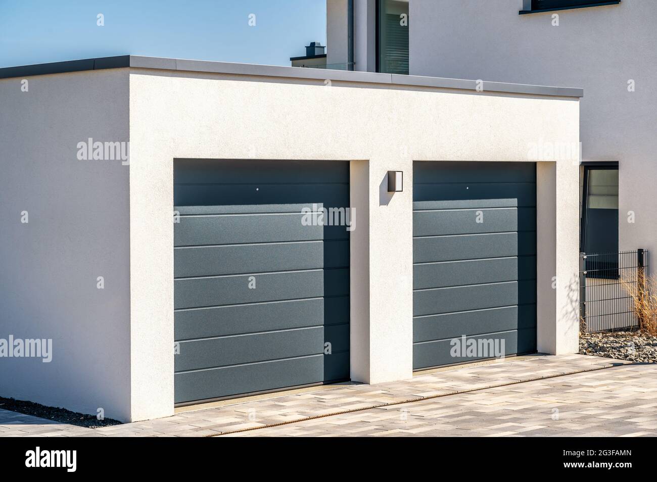Moderne Doppelgarage mit Sektionaltüren als sicherer Parkplatz im eigenen Haus Stockfoto