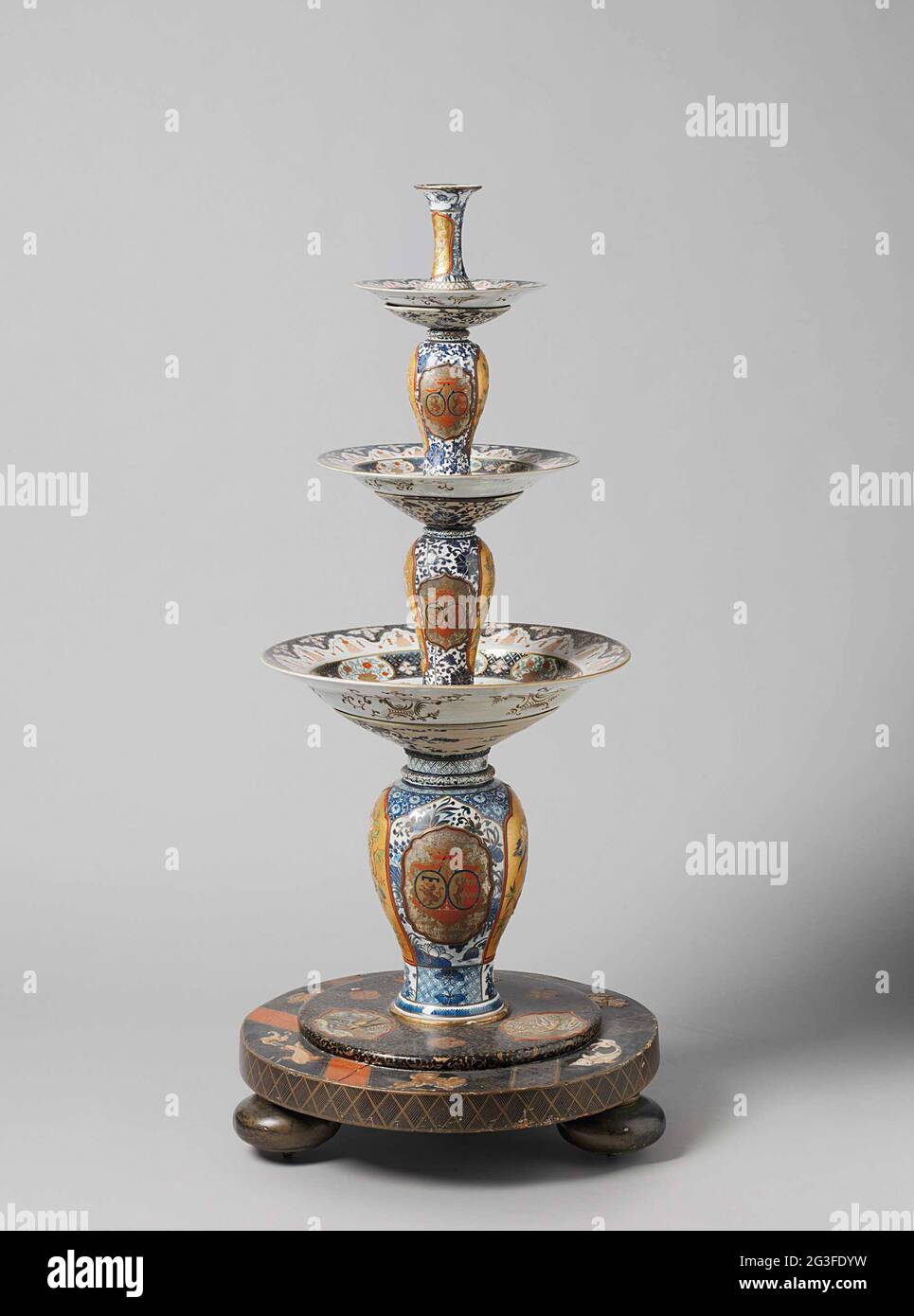 Etagere. "Dummer Diener", bestehend aus vier chinesischen Vasen und drei japanischen Imari-Platten mit den Waffen von Brederode-van Buren. Der Fuß und die Vasen sind mit Lack verziert: Der Fuß in Gold auf schwarzem Grund, mit Medaillons, die bunte Vögel auf goldenem Grund zeigen. Die Vasen tragen auch solche Medaillons. Stockfoto