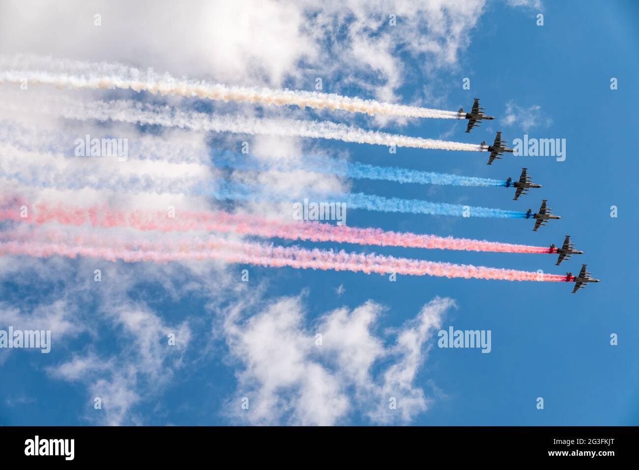 Moskau, Russland - 05. Mai 2021: Acht Angriffsflugzeuge Su-25 Frogfoot fliegen mit Rauch, gemalt in den Farben der russischen Flagge. Parade zu Ehren von VI Stockfoto