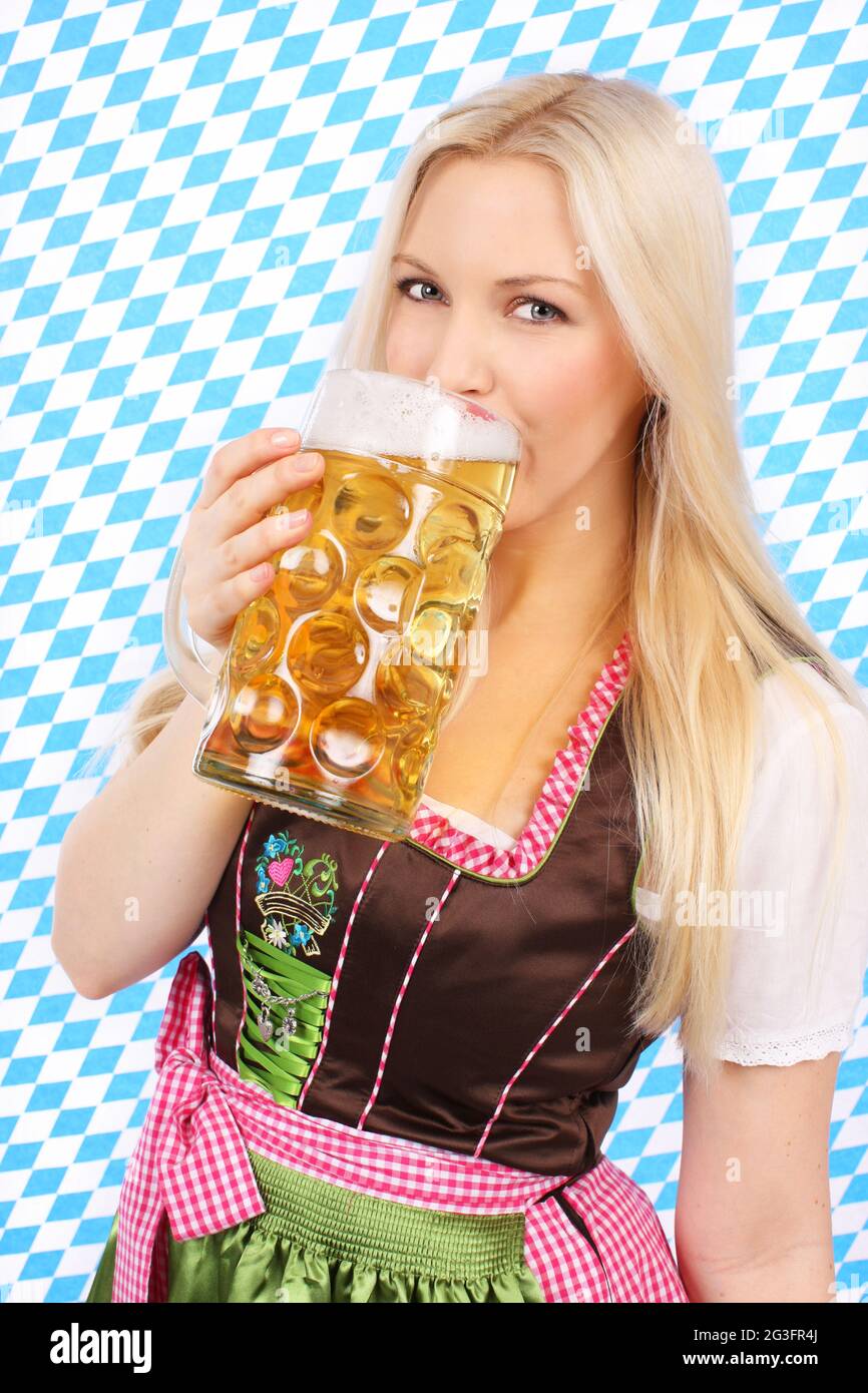 Hübsches Mädchen im Dirndl mit Massenjuggs Stockfoto